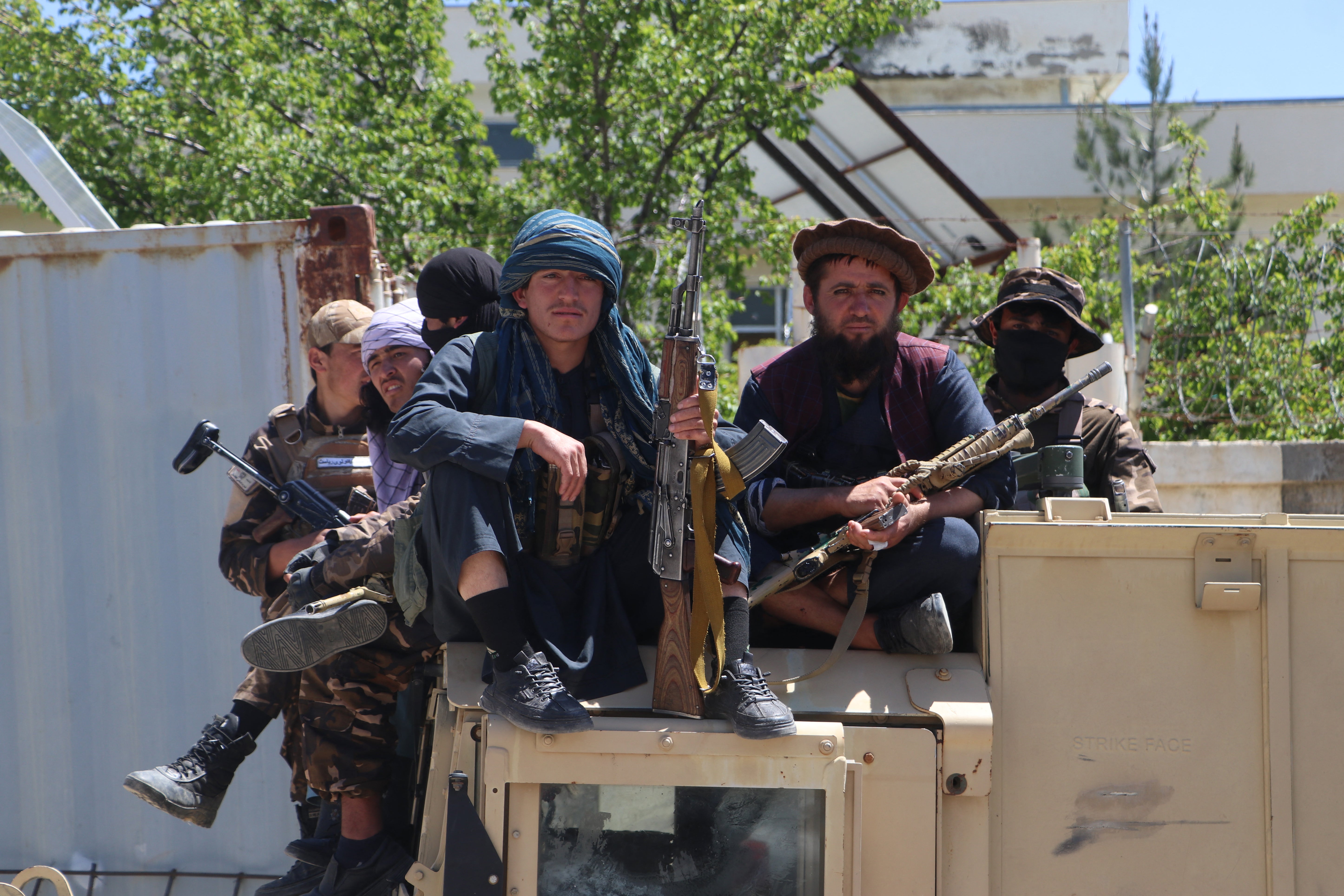 <p>Armed Taliban security personnel sit on a Humvee outside a mosque in Argo district, Badakhshan province</p>