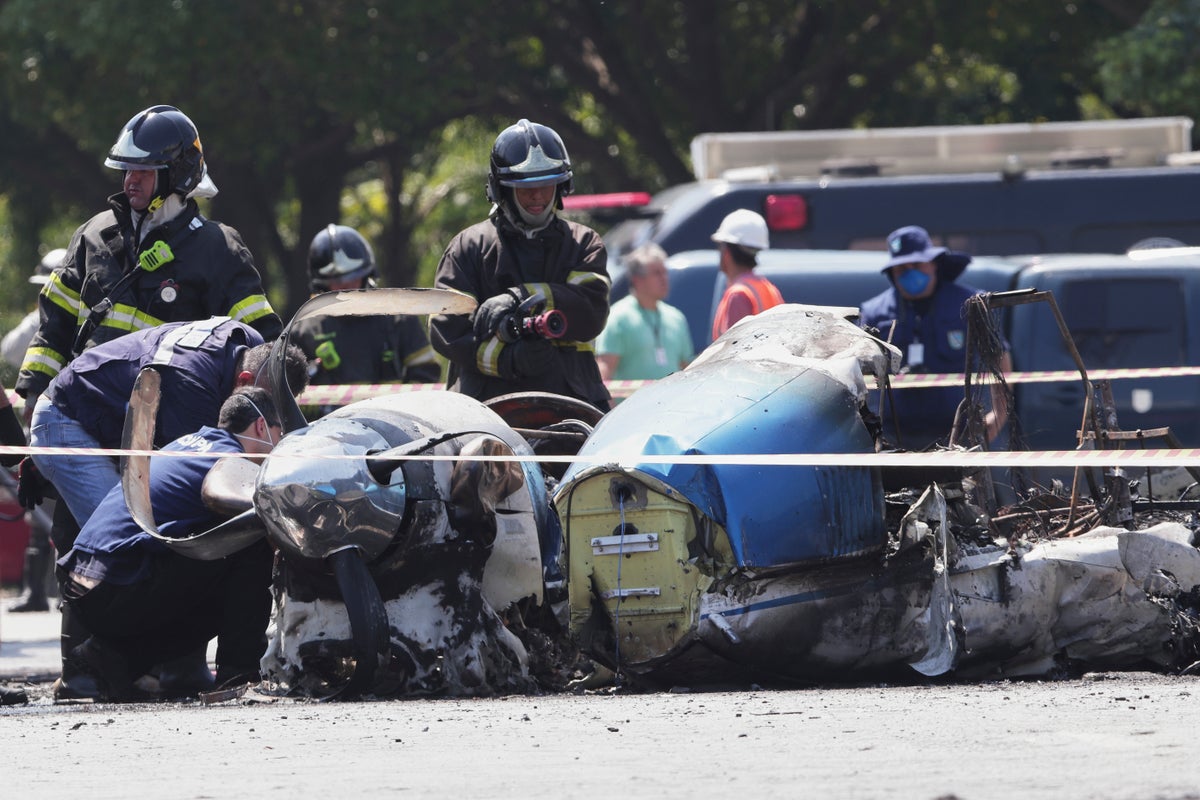 Plane wreckage burns after crashing into bus on busy Sao Paulo road