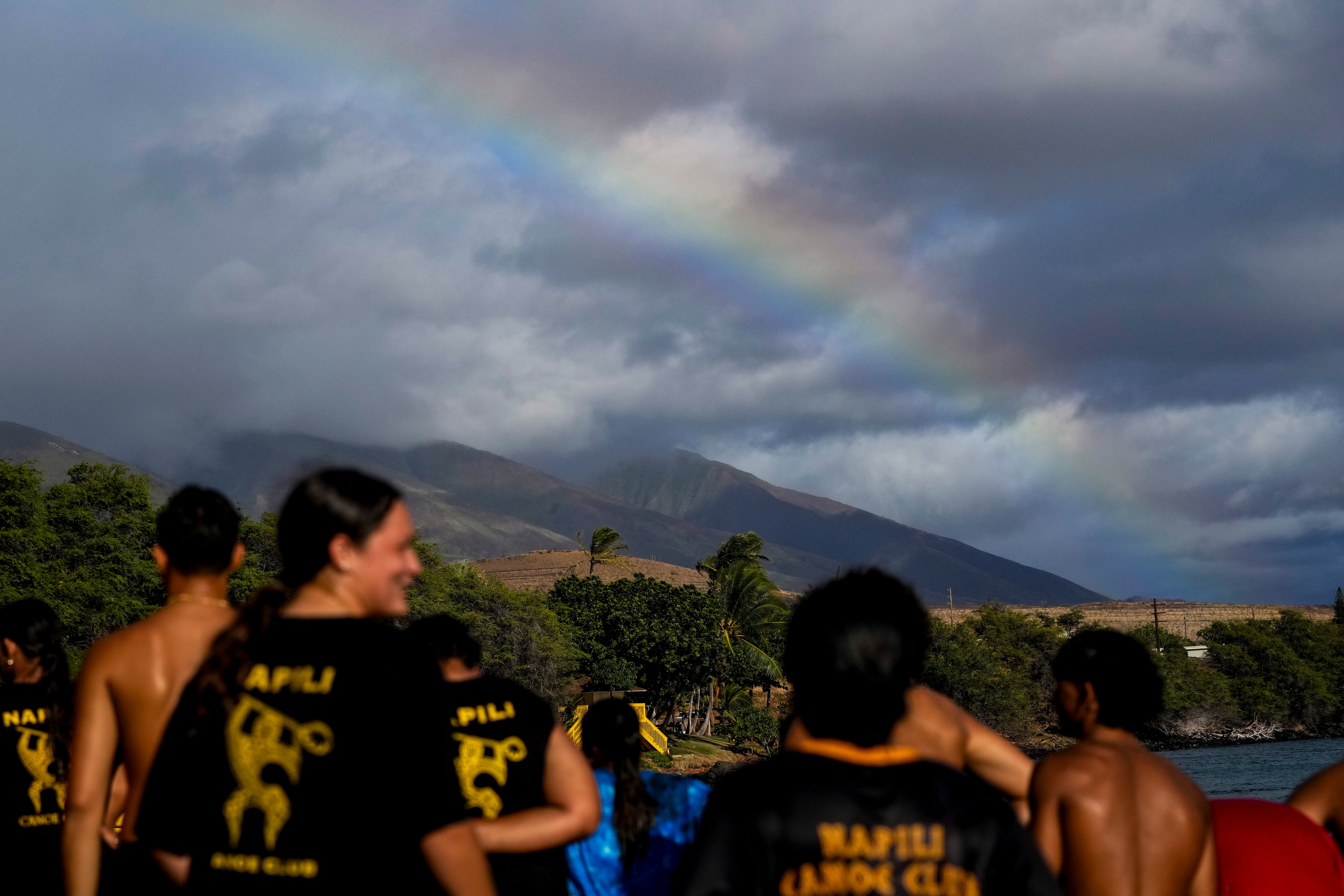 Un arcoiris se forma como miembros del Napili Canoe Club corren en la playa el lunes 8 de julio de 2024 en el parque Hanakao'o