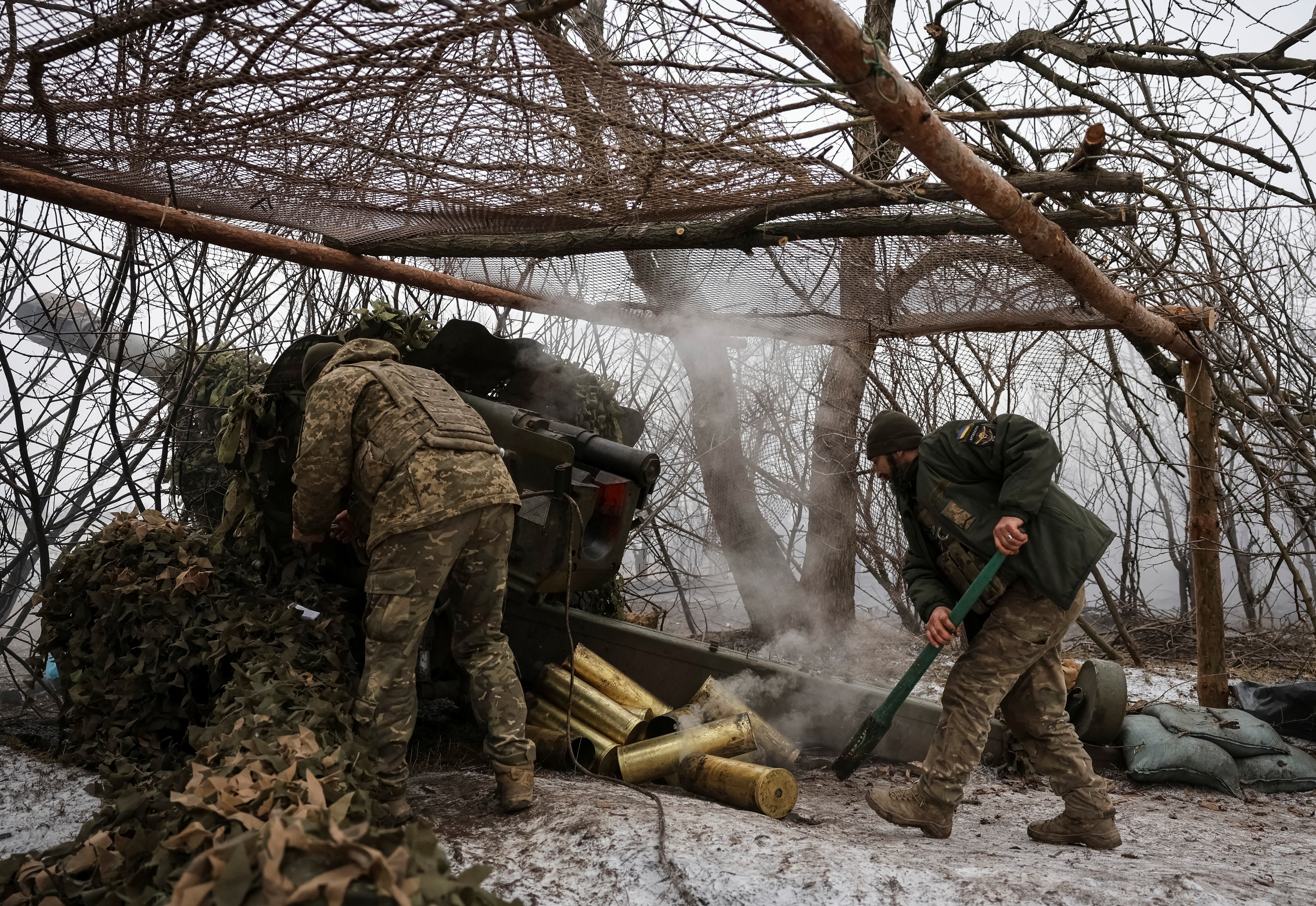 Ukrainian soldiers fire a D-20 howitzer toward Russian troops