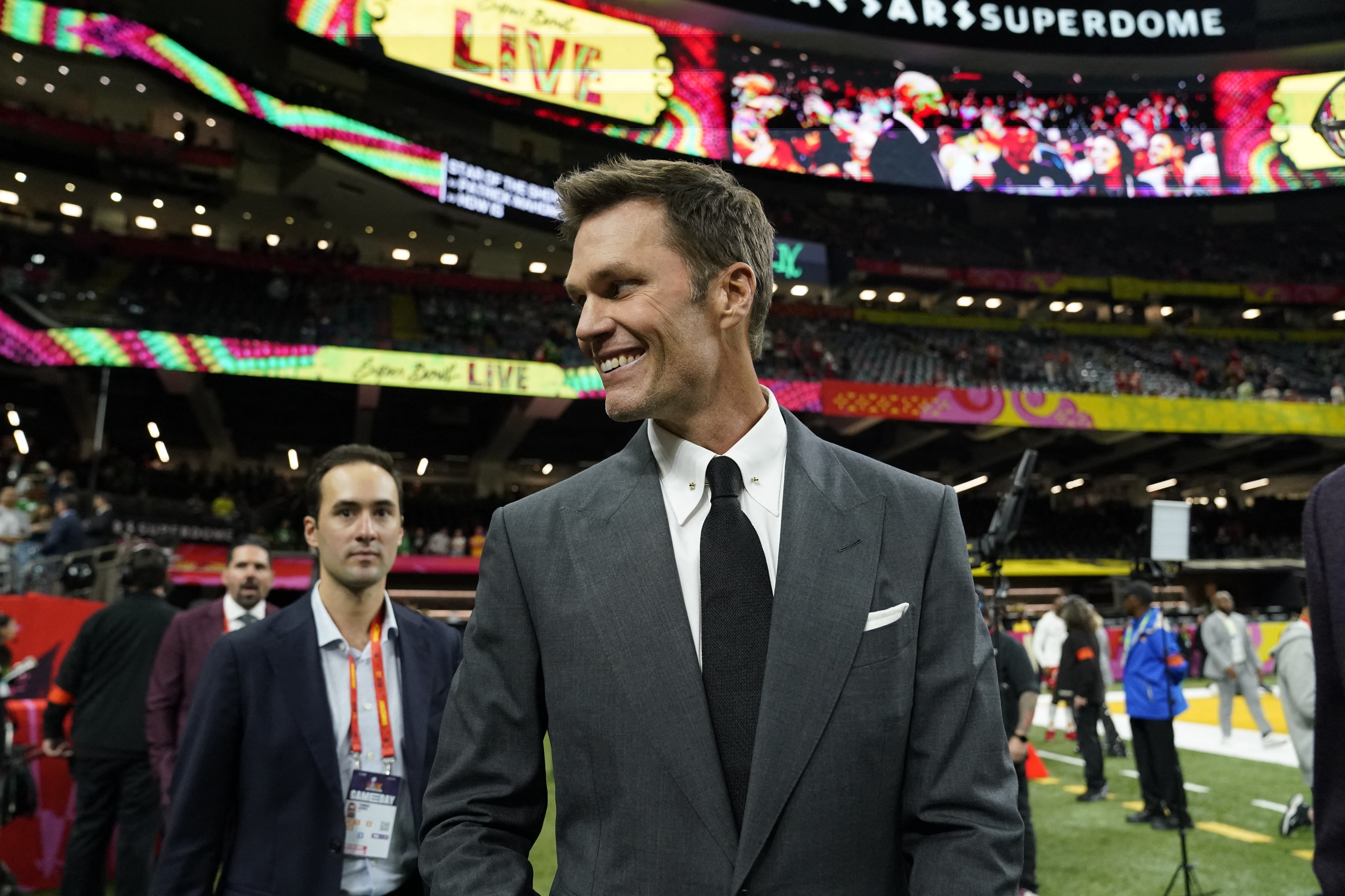 Fox analyst Tom Brady walks the sidelines before the start of Super Bowl LIX