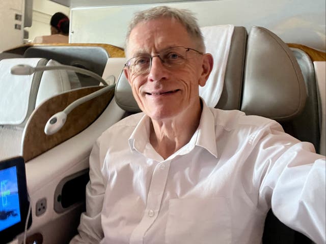 <p>Wide body, narrow seat: Simon Calder in his ‘dentist’s chair’ on board the Emirates Boeing 777</p>