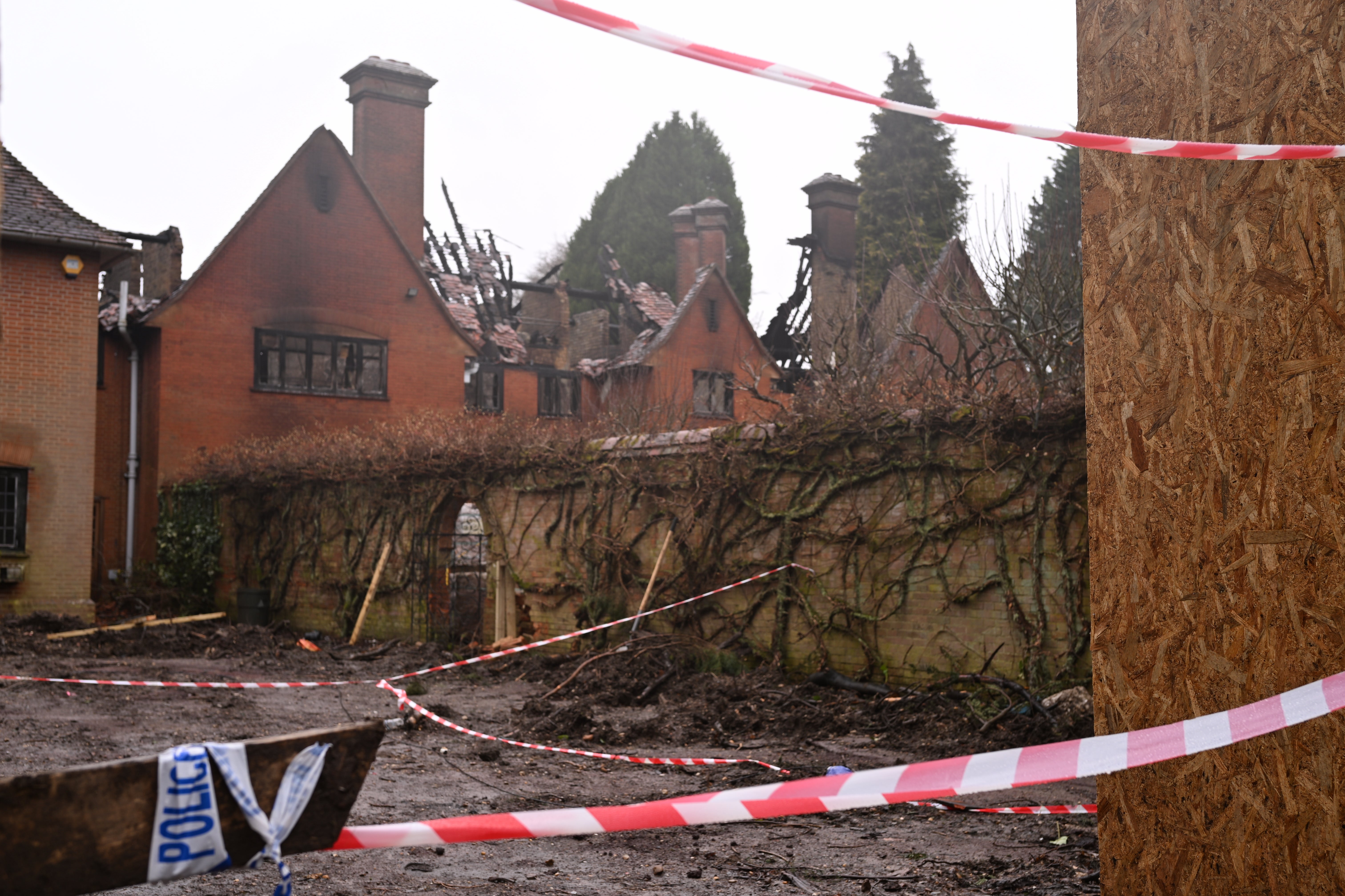 Police tape cordons off the eight-bedroom home after it burned down on Sunday morning