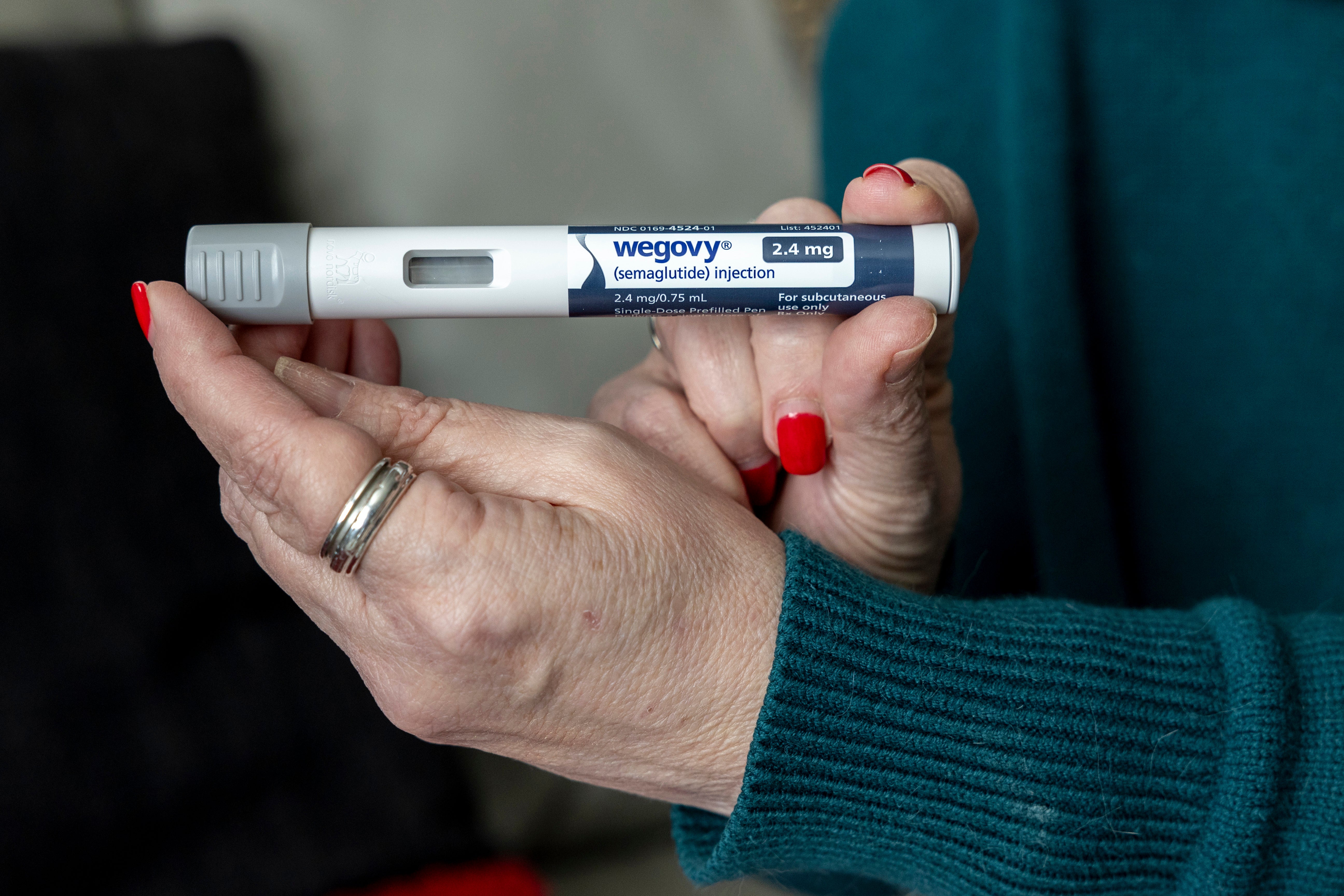 A woman holds up a dosage of Wegovy, a drug used for weight loss, at her home in Front Royal, Va., on March 1, 2024.