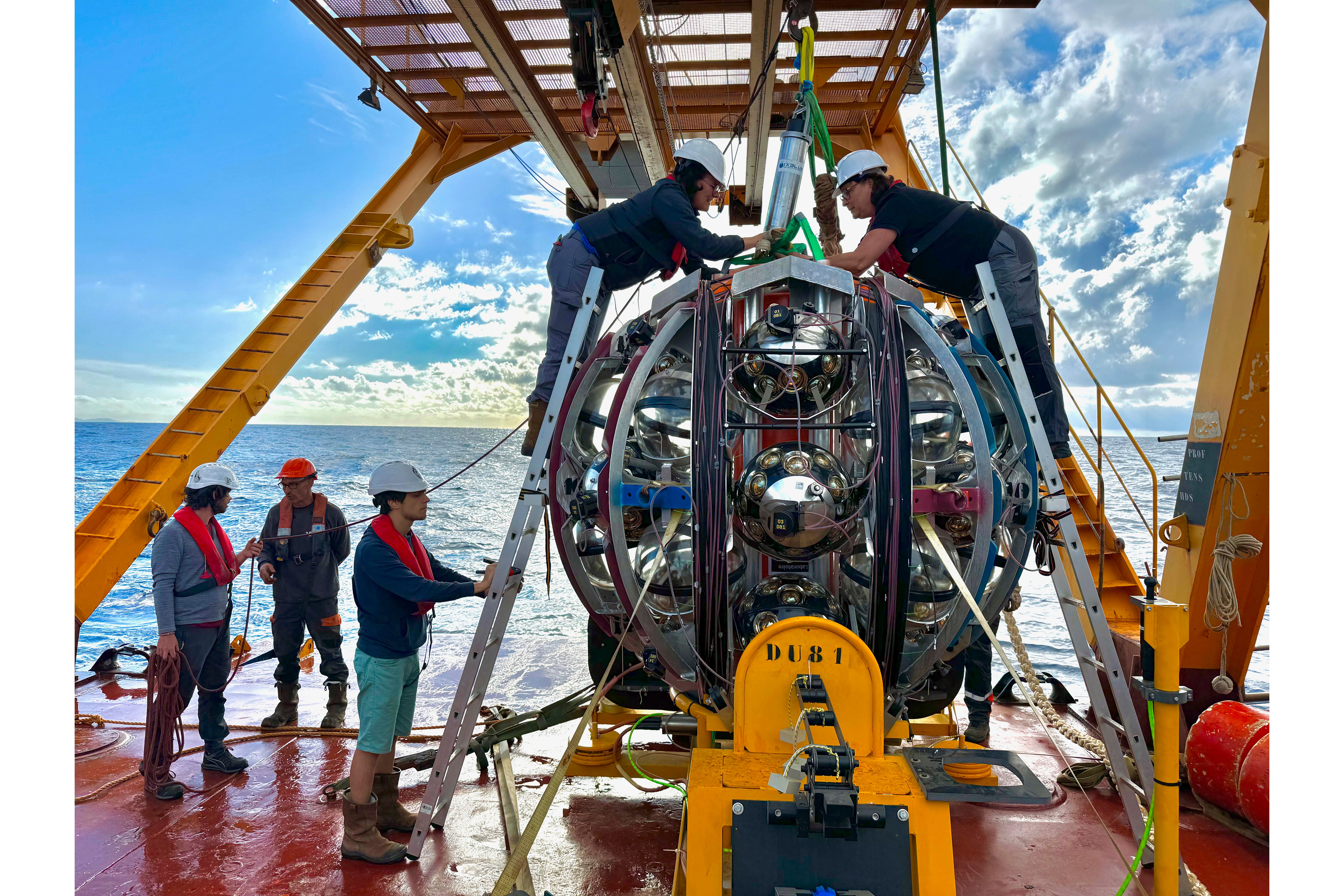 Scientists prepare to lower equipment used to detect neutrinos into the Mediterranean Sea. (Paschal Coyle, KM3NeT via AP)