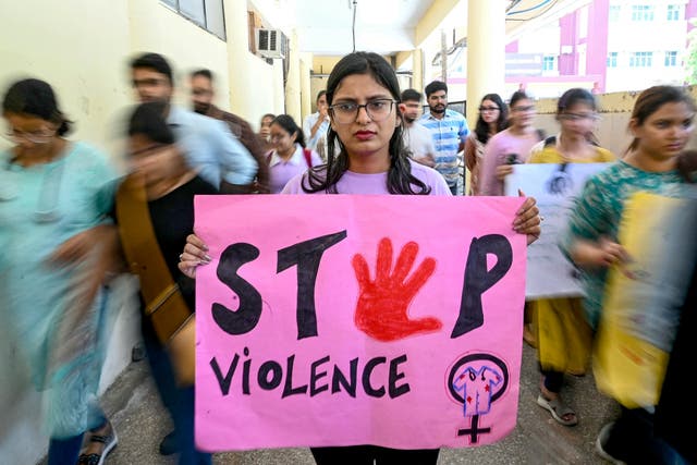 <p>A medical professional holds a placard during a demonstration to condemn the rape and murder of a medic from Kolkata</p>