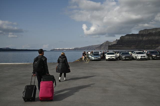 <p>Motorists and travellers wait on the quayside for the arrival of the ferry at the port on the Greek Island of Santorini on February 3, 2025</p>