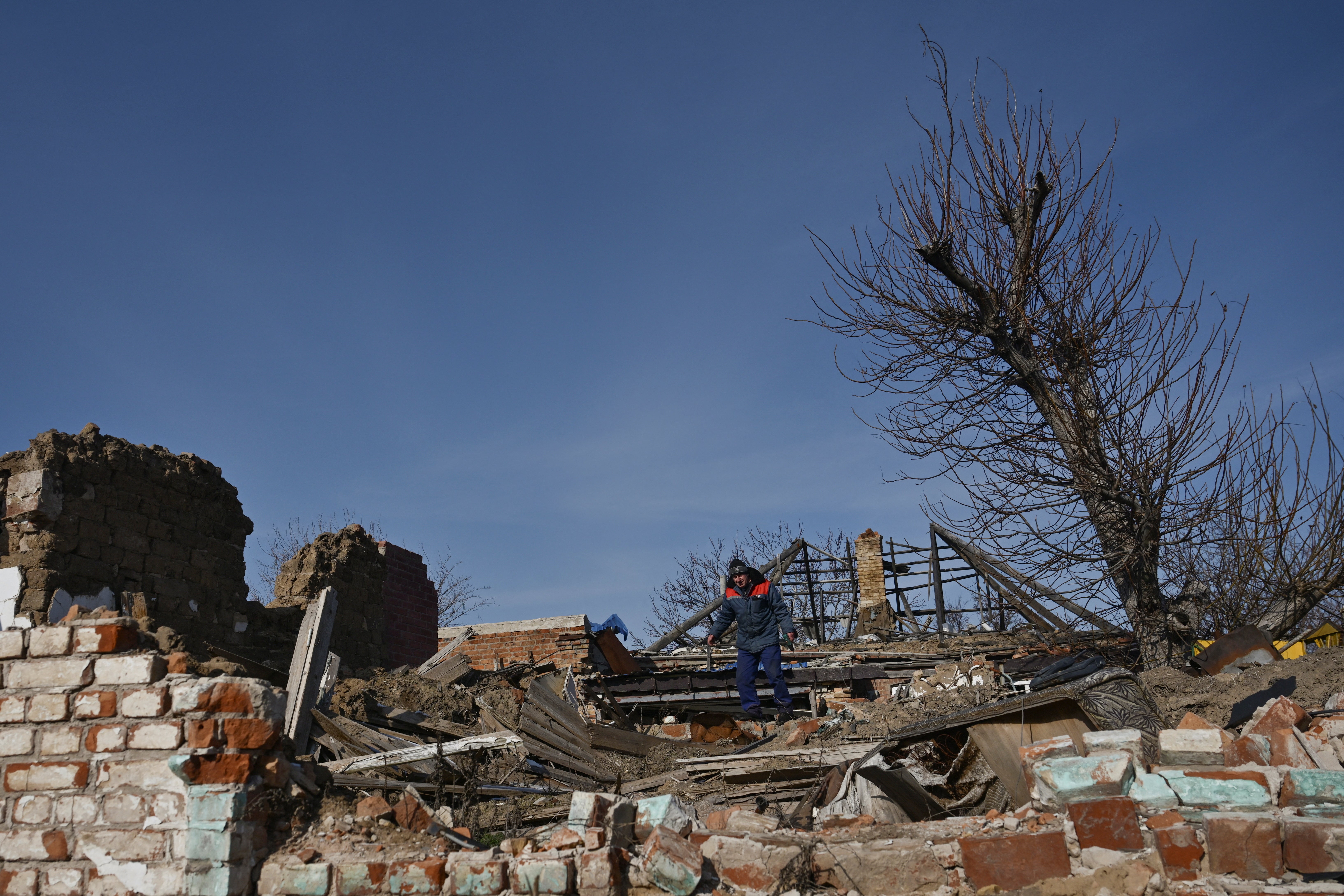 A resident walks on debris of buildings destroyed by Russian military strikes in the frontline town of Orikhiv, Zaporizhzhia, southeastern Ukraine