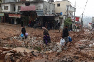 Residents walk along the streets destroyed by Israeli bulldozers in Alfara's camp