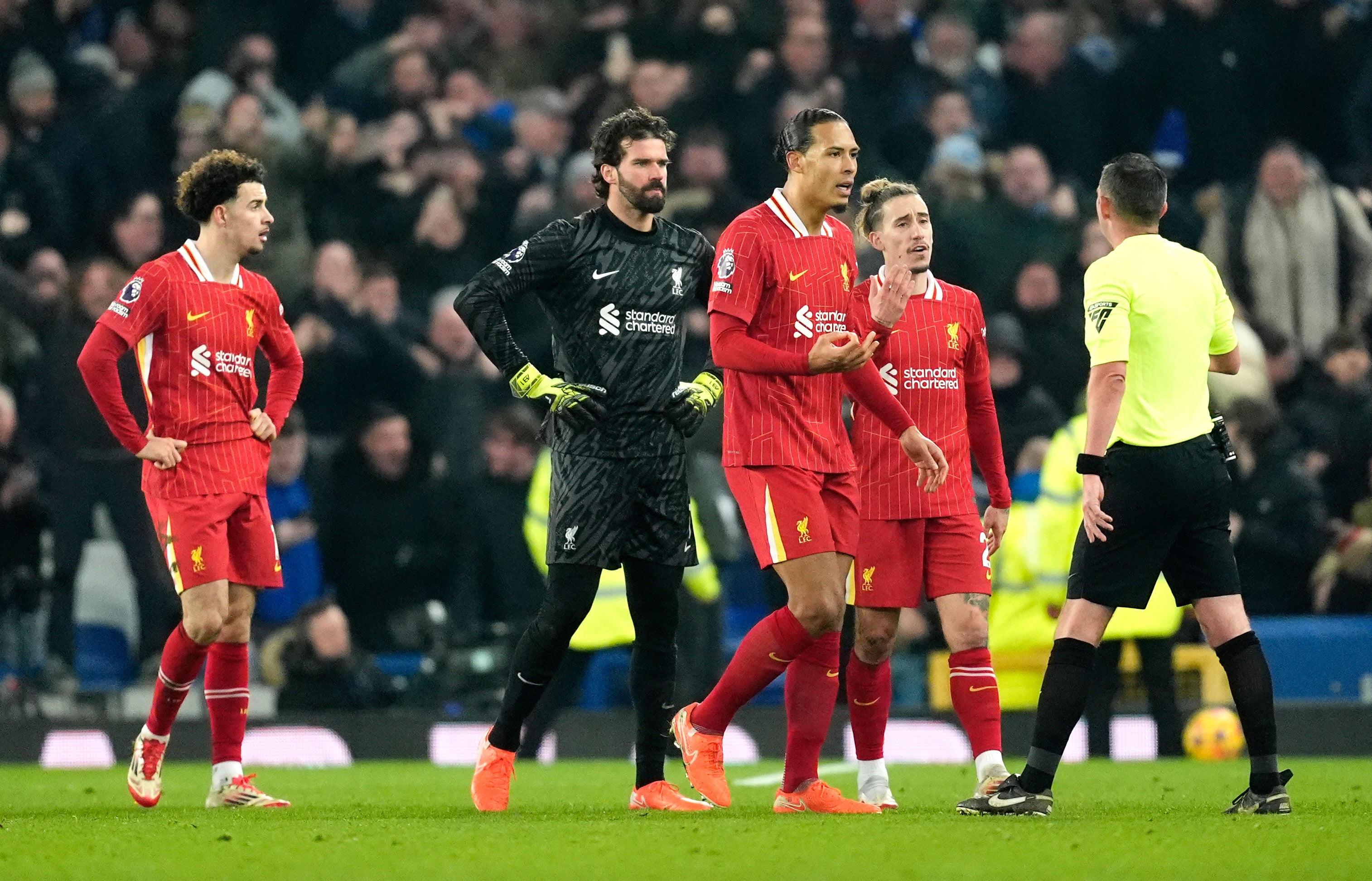 Liverpool's Virgil van Dijk and players speak to referee Michael Oliver