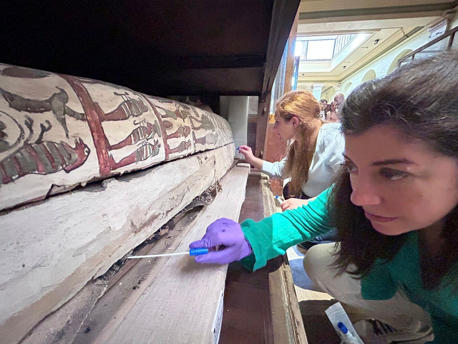 University College of London lecturer Dr Cecilia Bembibre, foreground, and Emma Paolin, a PhD researcher at University of Ljubljana, take swabs from a mummy