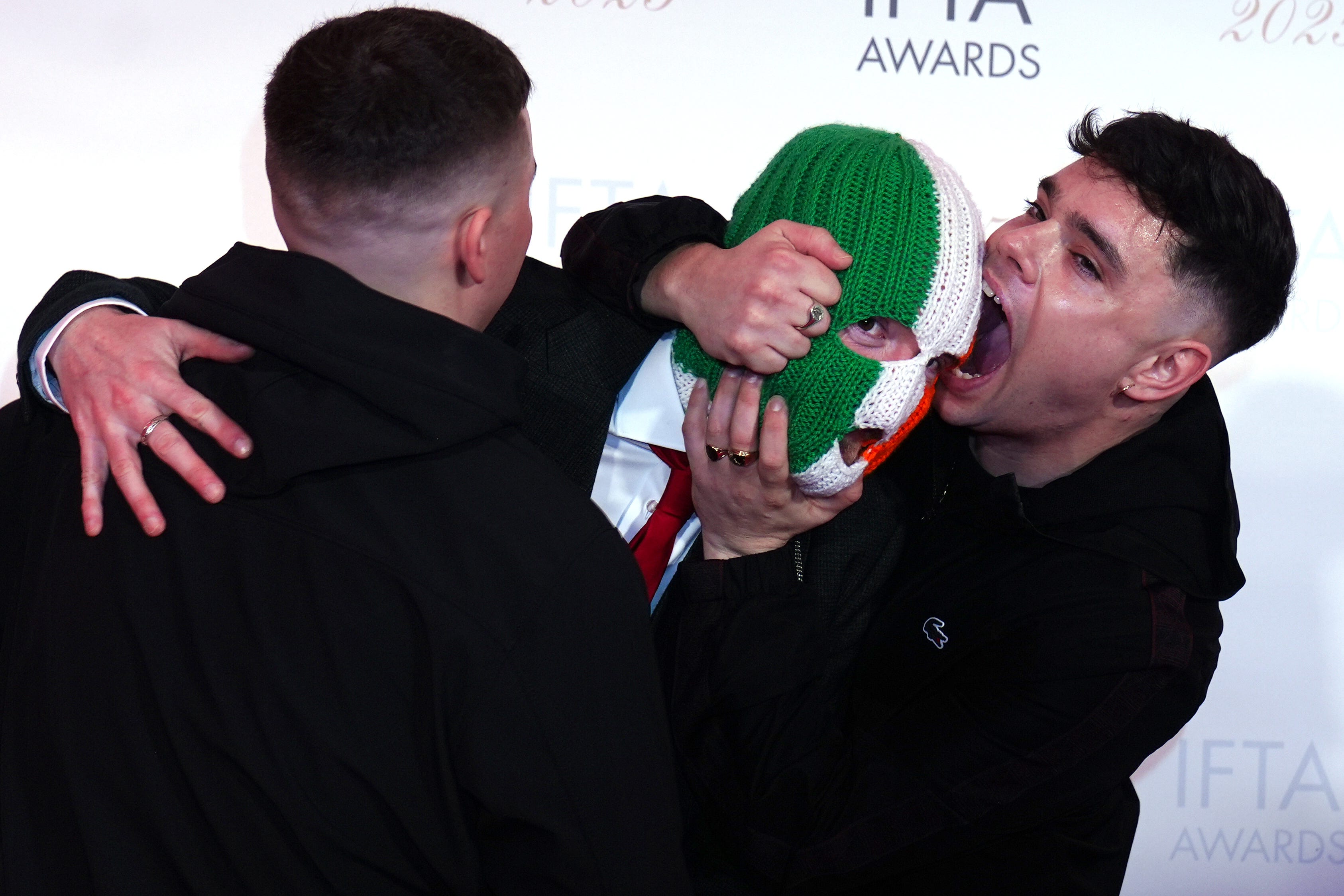 (left to right) members of Kneecap, Mo Chara, JJ O’Dochartaigh and Moglai Bap play-fighting at the Iftas (Brian Lawless/PA)