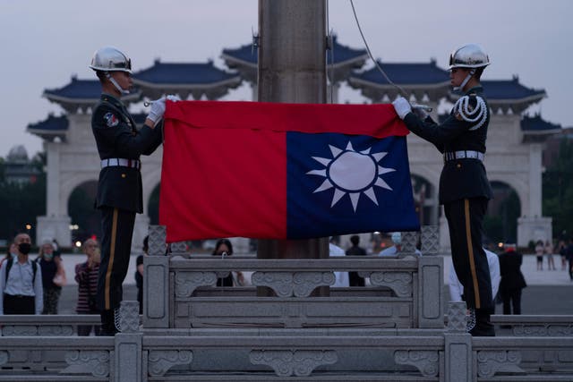 <p>Taiwanese soldiers lower the flag during a ceremony in Taipei</p>