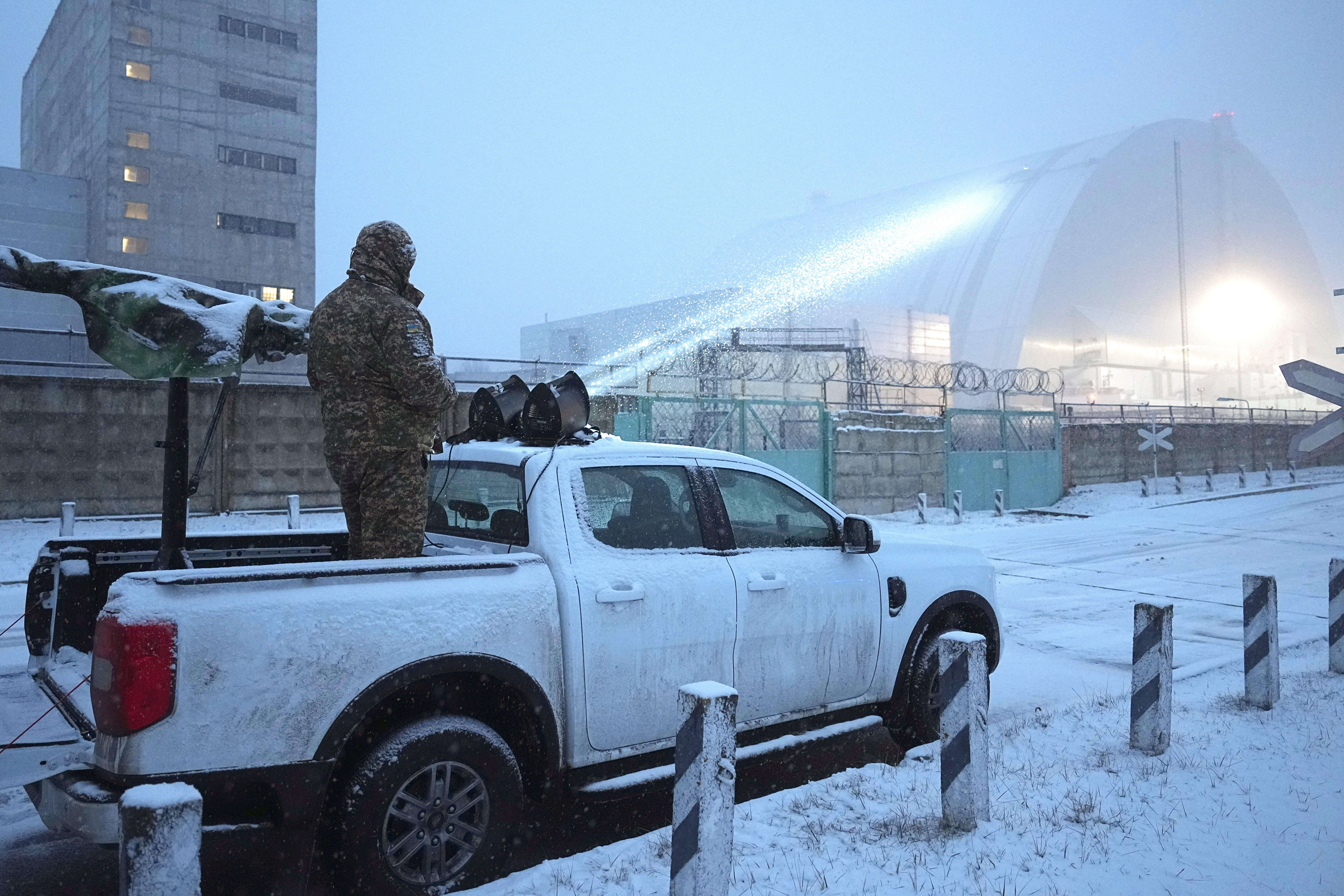 Ukrainian serviceman stands on a vehicle with anti-aircraft gun after a drone attack at the former Chernobyl nuclear power plant