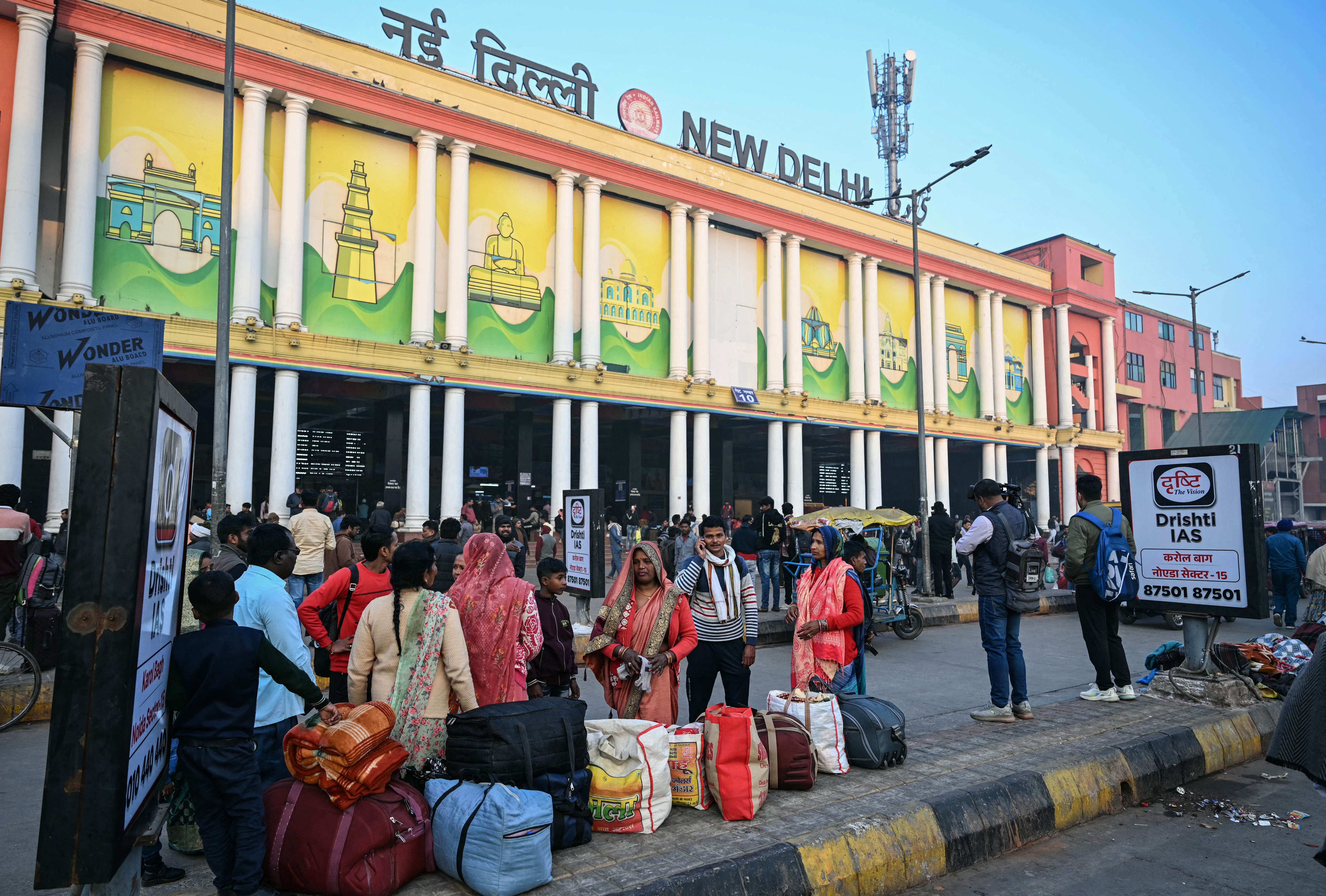 <p>A general view shows passengers standing outside the New Delhi railway station in the early morning hours in New Delhi on Sunday</p>