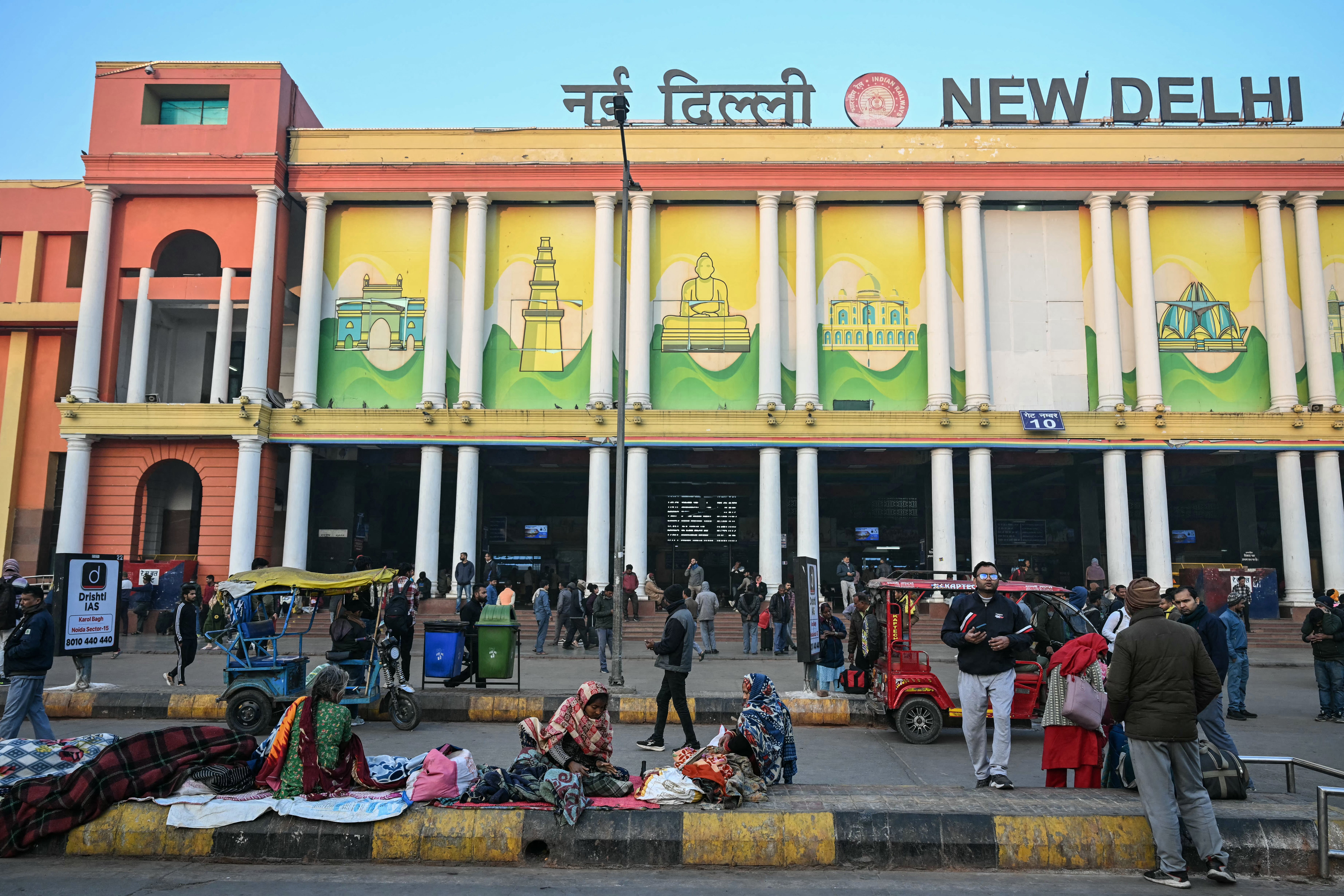 A general view shows passengers standing outside the New Delhi railway station in the early morning hours