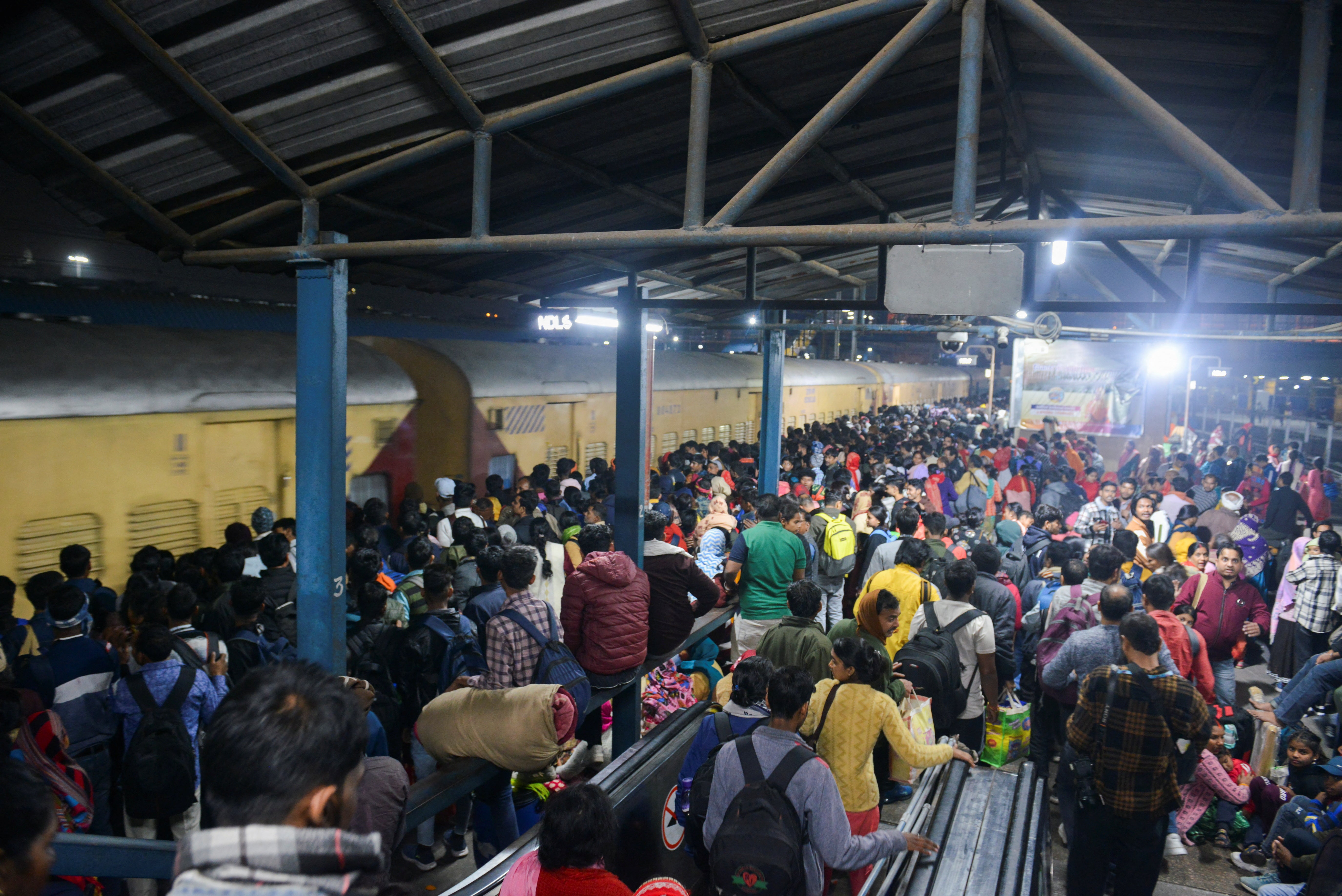 Passengers wait to board a train to Uttar Pradesh at the New Delhi railway station