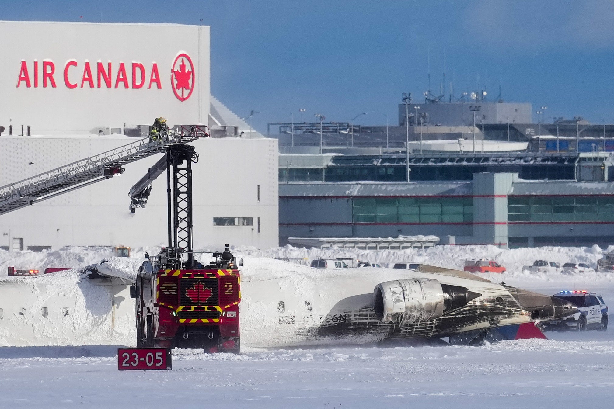 A Delta flight sits upside down on the Toronto Pearson International Airport’s runway after crashing Monday afternoon