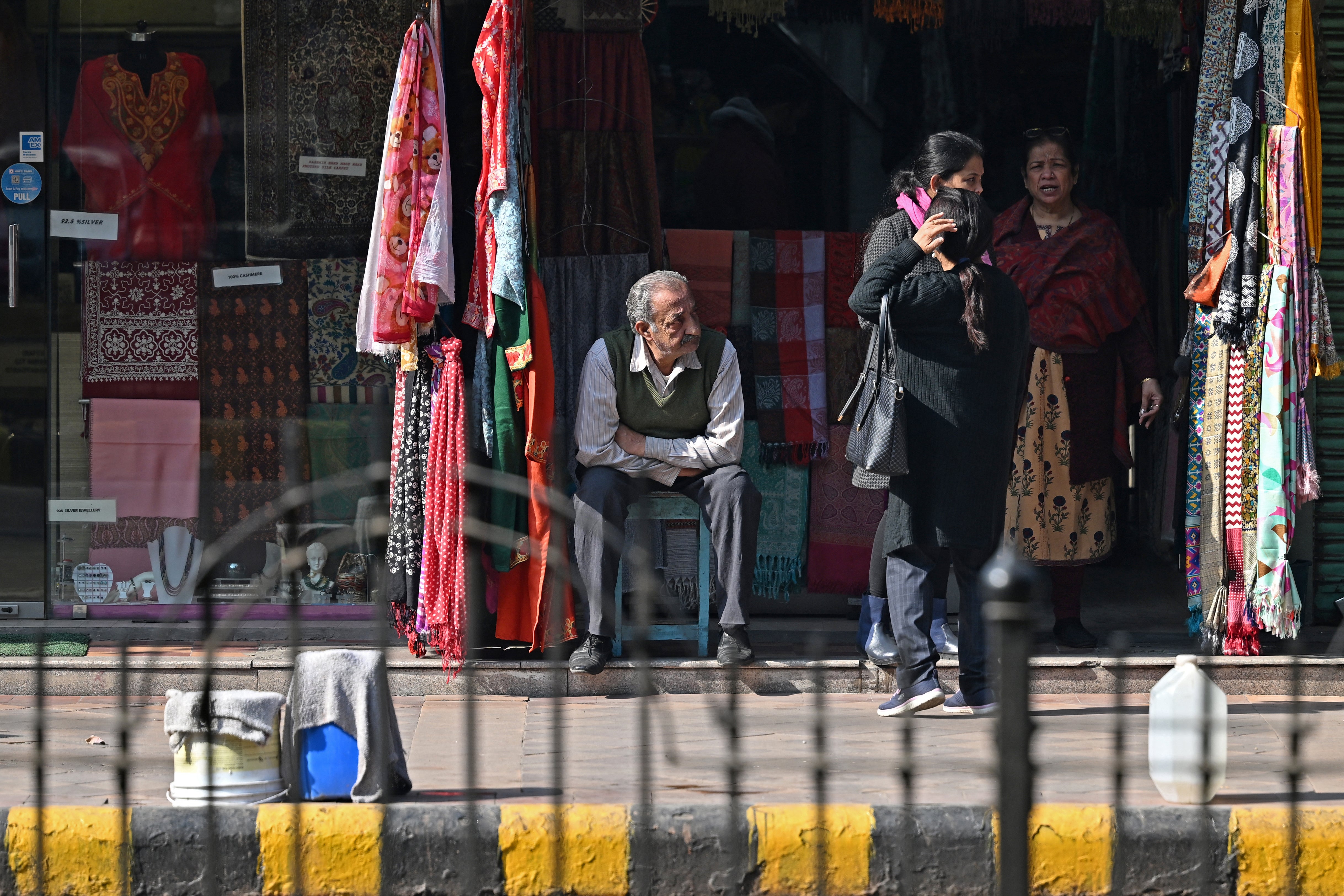 <p>File: A shopkeeper sits along a street on a cold winter day in New Delhi</p>