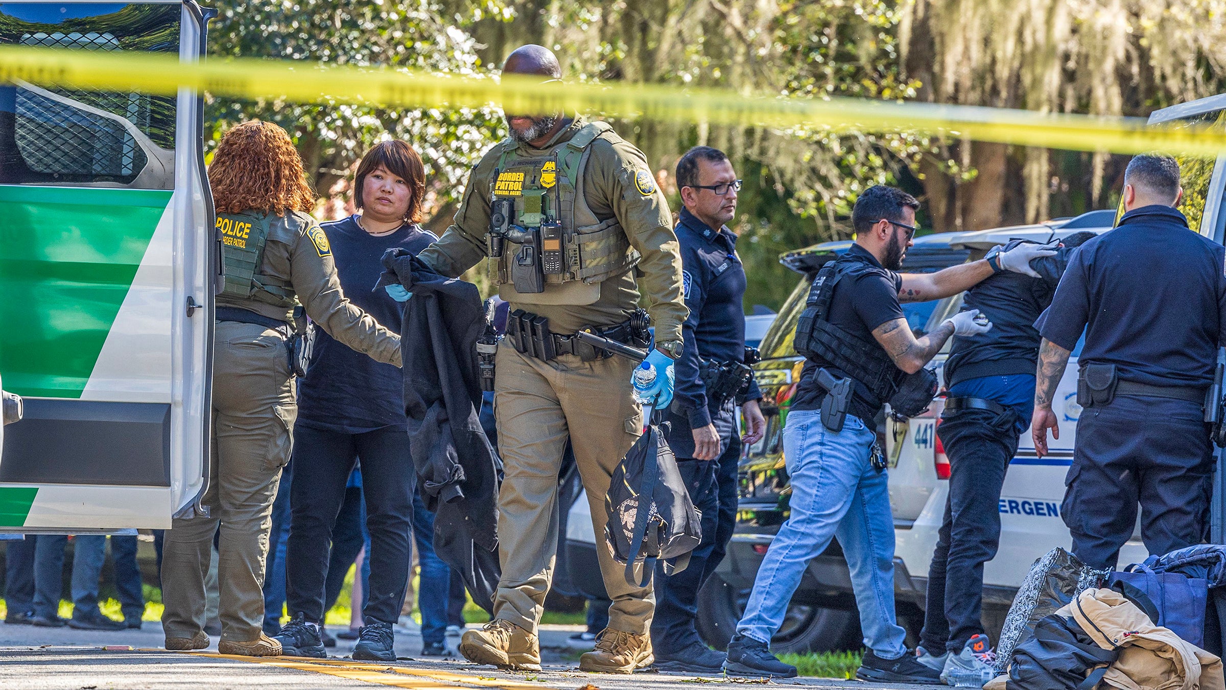 Law enforcement officers detain migrants in the area in Coral Gables