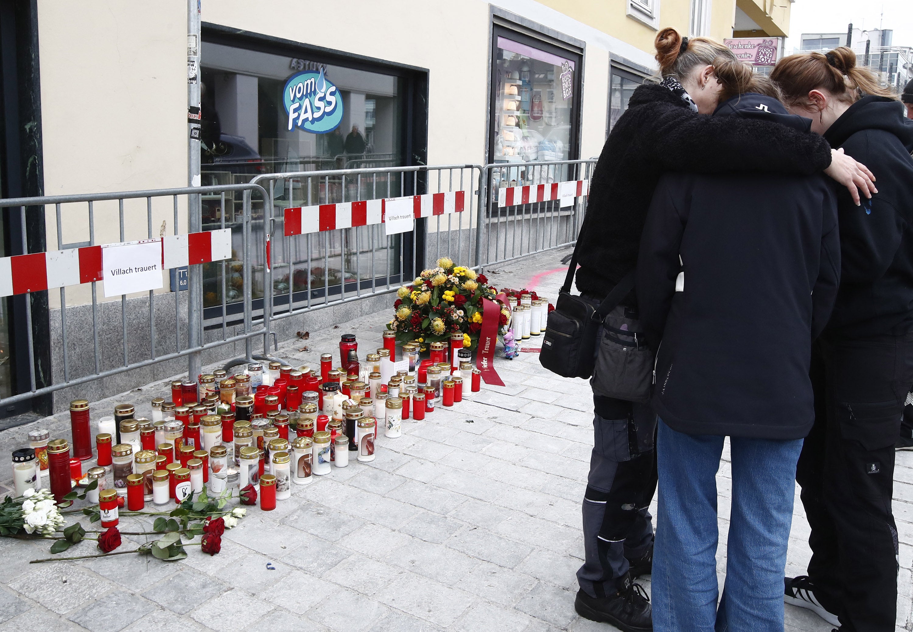 People mourn on 16 February 2025 at the site where a man randomly attacked passers-by with a knife and stabbed to death a teenager and wounded five other people