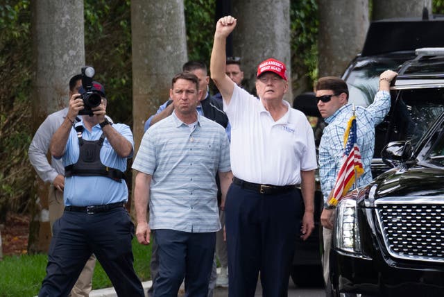 <p>Trump gestures to supporters as he leaves the Trump International Golf Club on Monday</p>