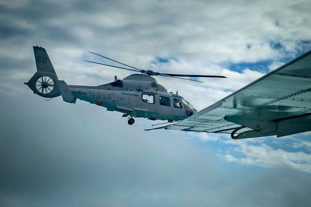 <p>A Chinese Navy helicopter flies close to a Philippine Bureau of Fisheries and Aquatic Resources plane above Scarborough Shoal</p>