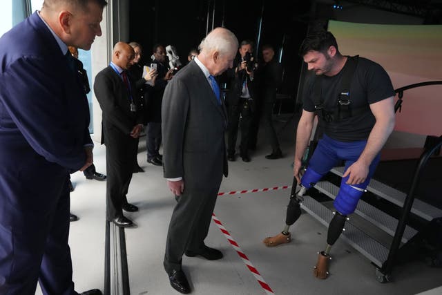 The King speaks to David Henson, a former soldier and Paralympian and now a researcher during his visit to the Centre for Injury Studies at Imperial College London (Kirsty Wigglesworth/PA)