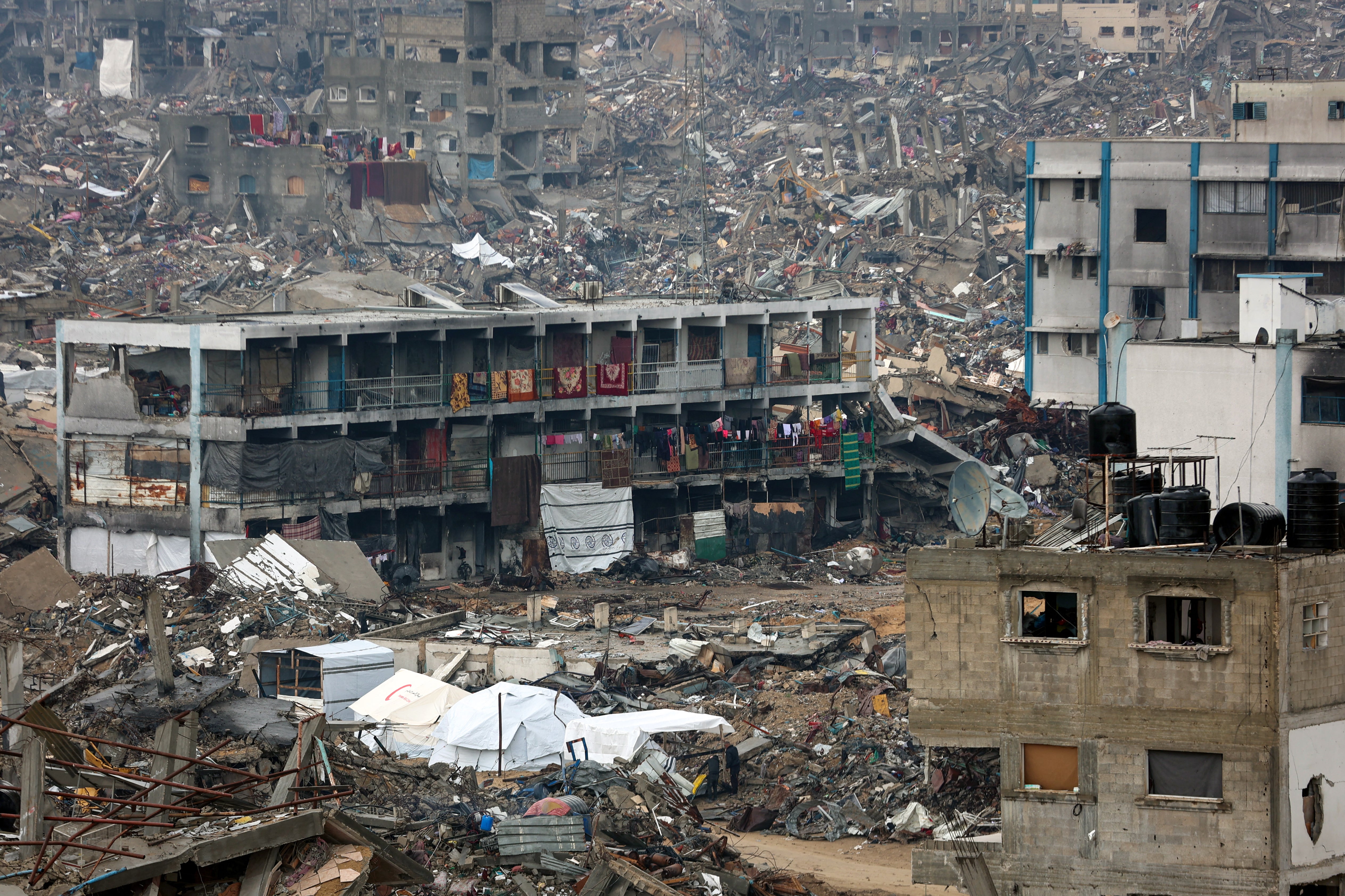<p>People camp in a heavily damaged UN school surrounded by destruction, as displaced Palestinians return to the northern areas of the Gaza Strip, in Jabalia, on 23 January 2025, during a ceasefire in the war between Israel and Hamas. In the war-battered Gaza Strip, displaced Palestinians set off on foot or by car to return home as trucks loaded with sorely needed humanitarian aid funnelled into the devastated territory. The truce mediated by Qatar, Egypt and the United States began on 19 January on the eve of Donald Trump’s inauguration for a second term as US president</p>