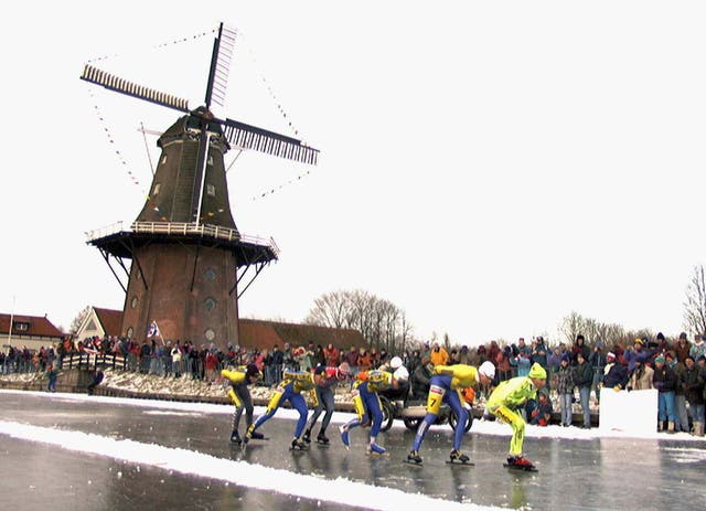 <p>Skaters pass a windmill at the village of Birdaard, northern Netherlands during the ‘Elfstedentoch’ (eleven-cities-course) race on Jan. 4, 1997</p>