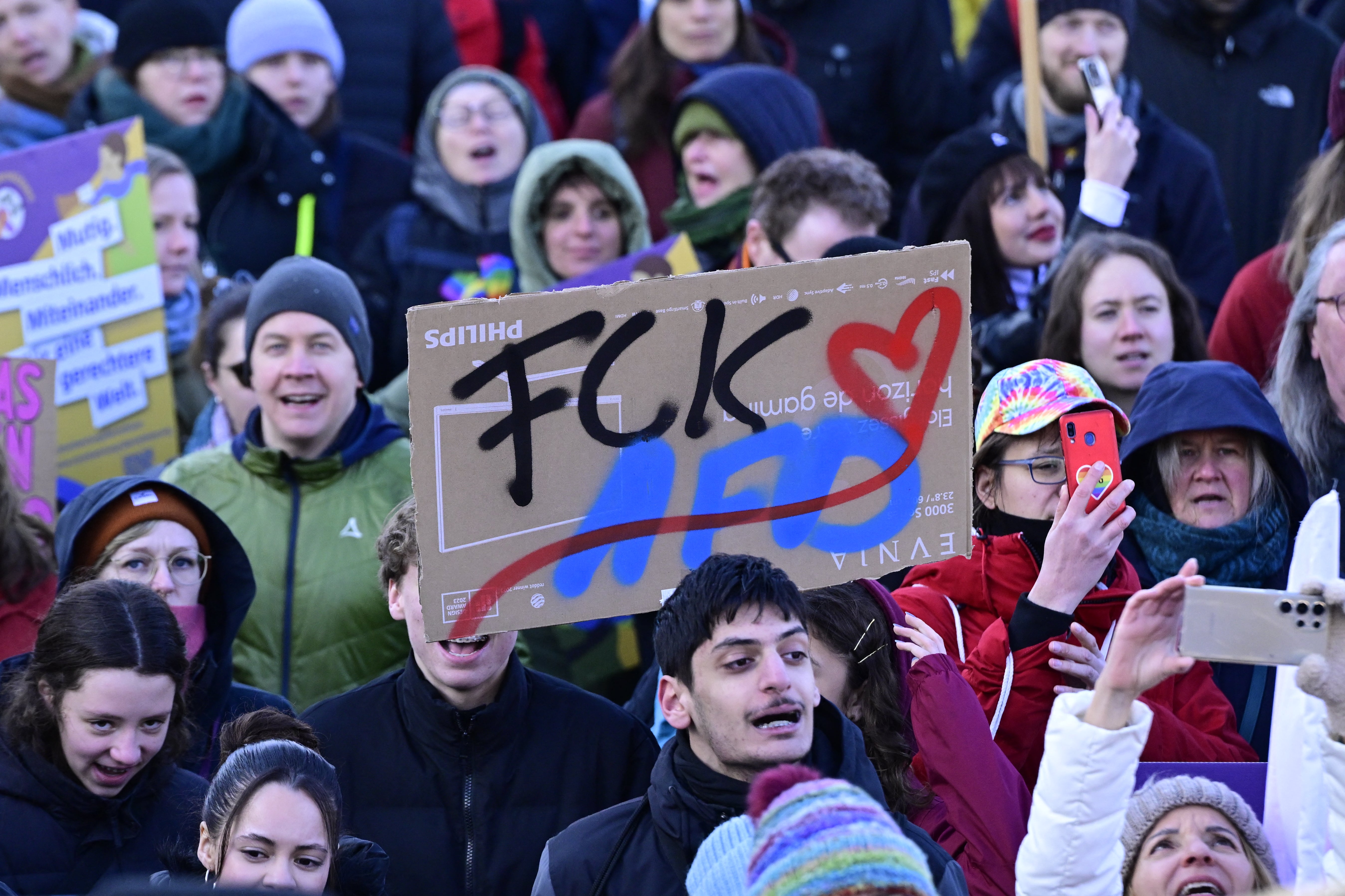 A demonstrator holds up a placard reading 