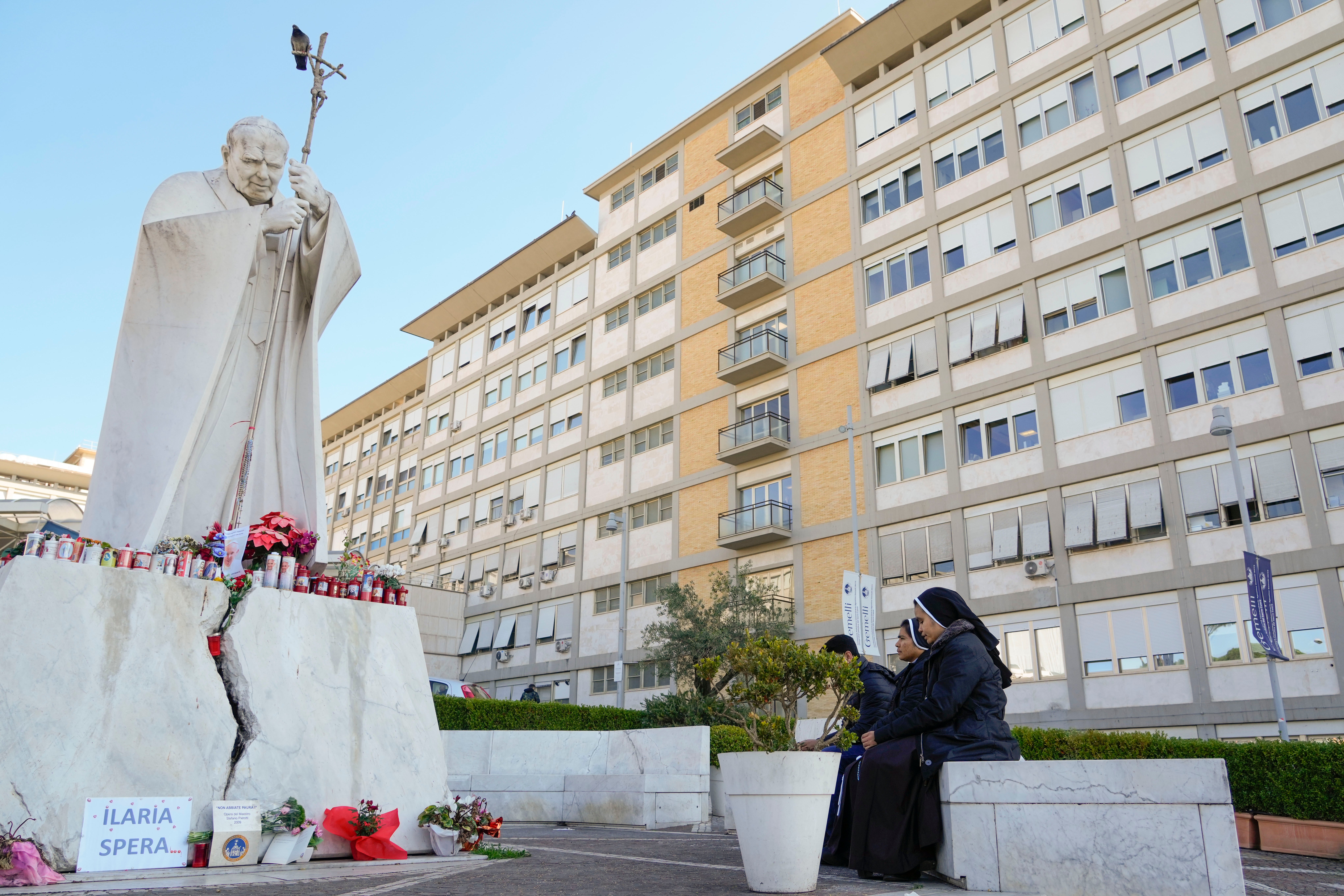 Nuns pray in front of the statue of late Pope John Paul II outside the Agostino Gemelli Polyclinic where Pope Francis is battling pneumonia in Rome on Saturday