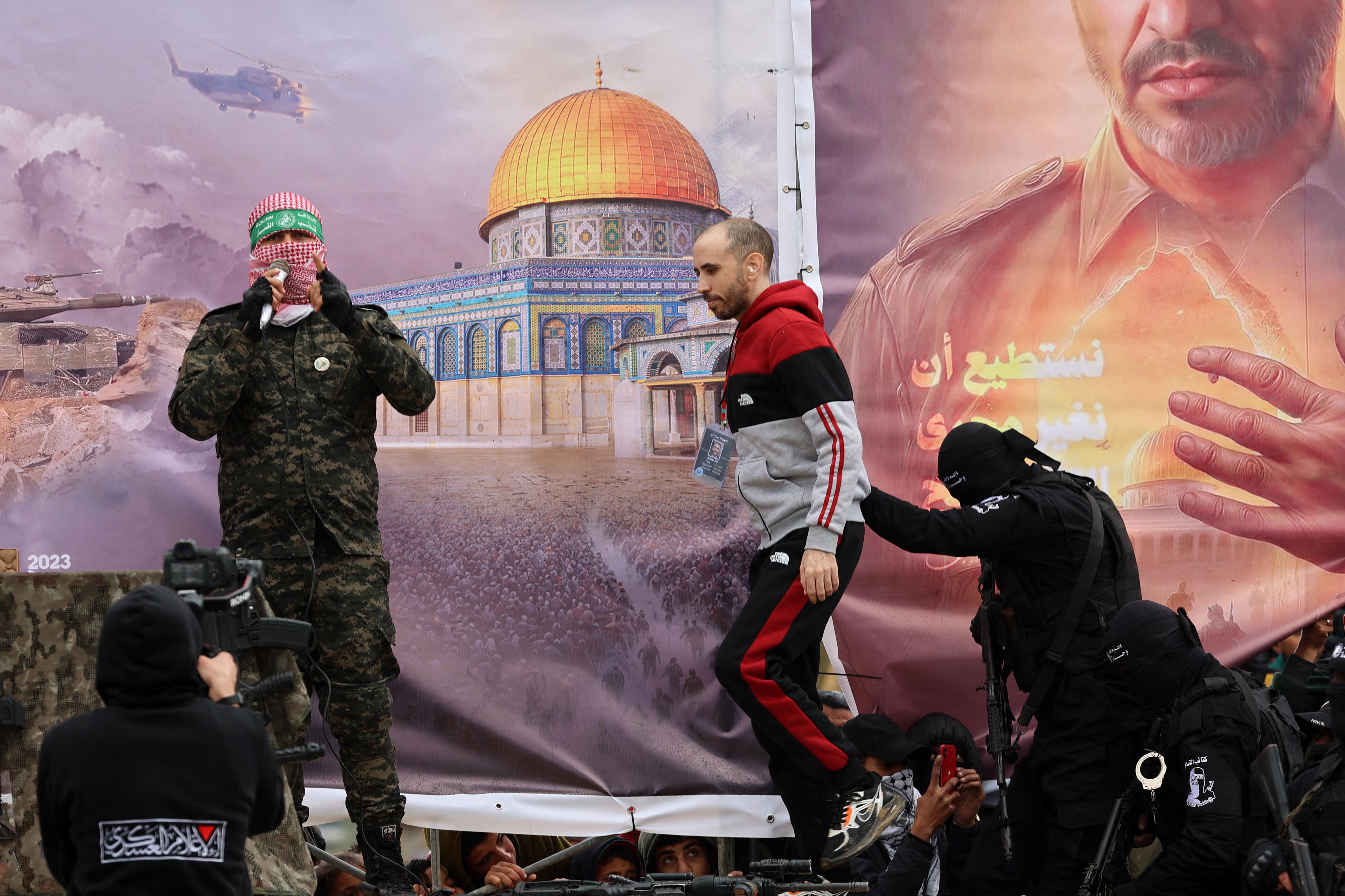 Tal Shoham is walked onto a stage as he is released by Hamas in Rafah, southern Gaza