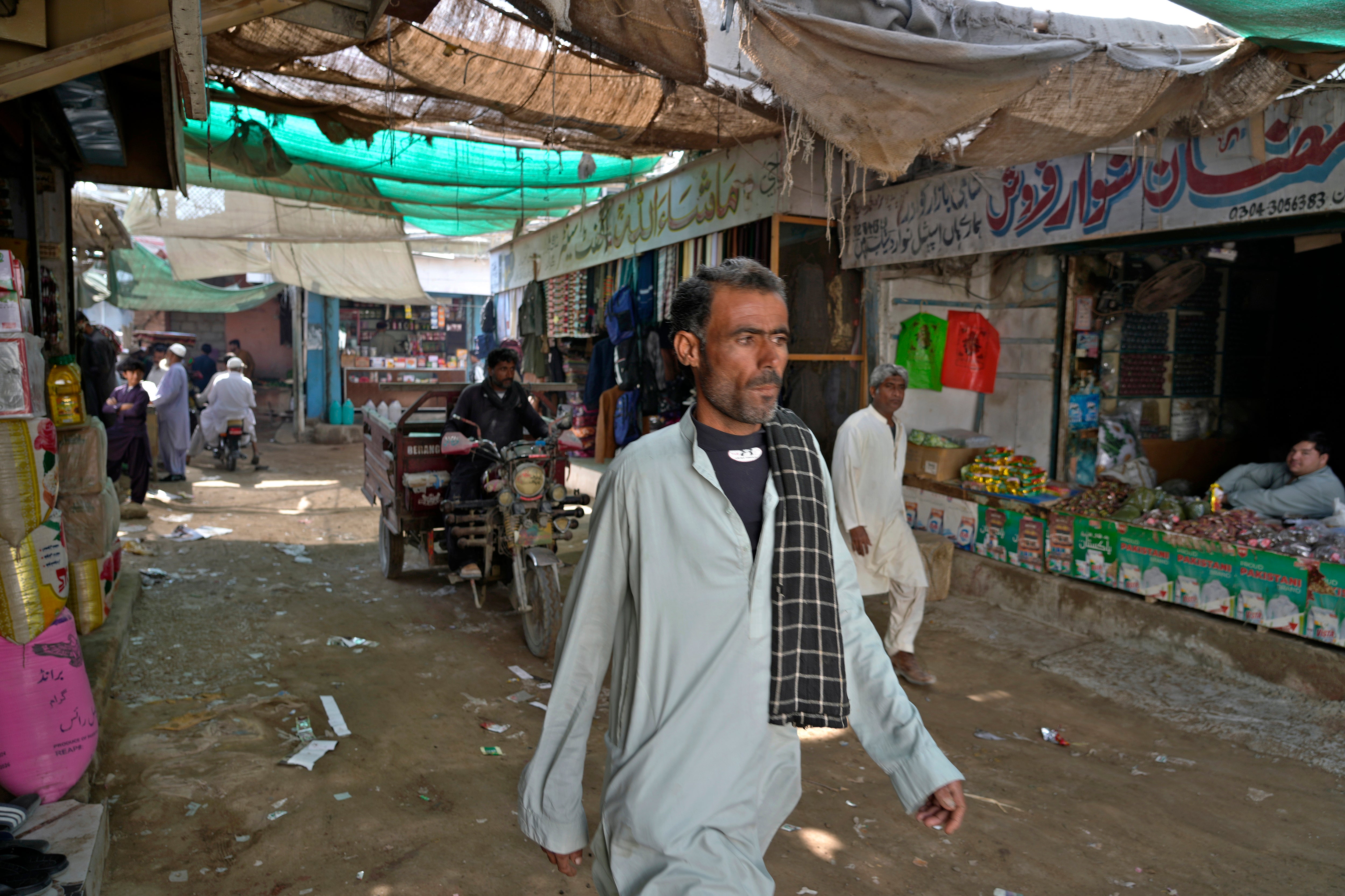 People walk through a market in the coastal city of Gwadar, in the southwest Pakistani province of Balochistan