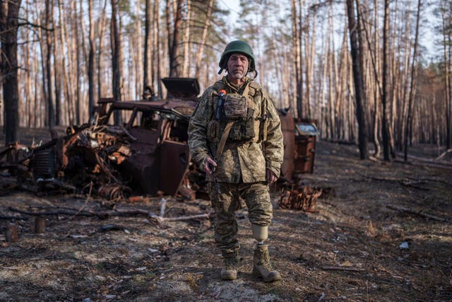 <p>Andrii Serhieiev, a Ukrainian soldier with the 53rd brigade who lost a leg in battle, stands in front of a destroyed Russian armoured vehicle near the front line</p>