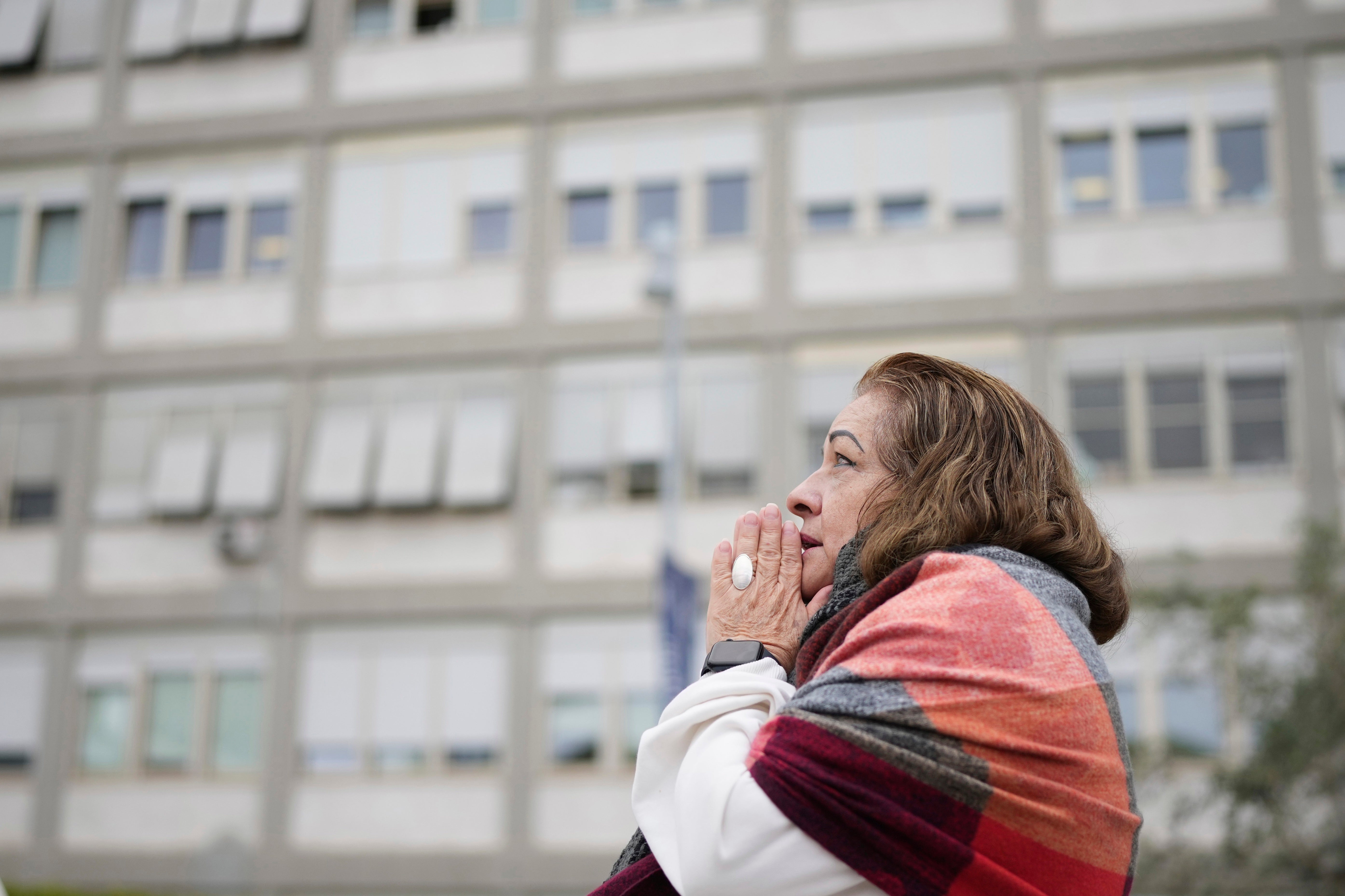 A woman prays at the Agostino Gemelli Polyclinic in Rome on Monday