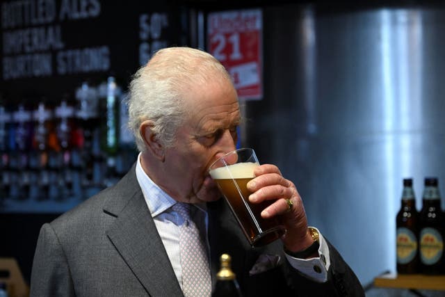 The King drinks a pint of beer (Jaimi Joy/PA)