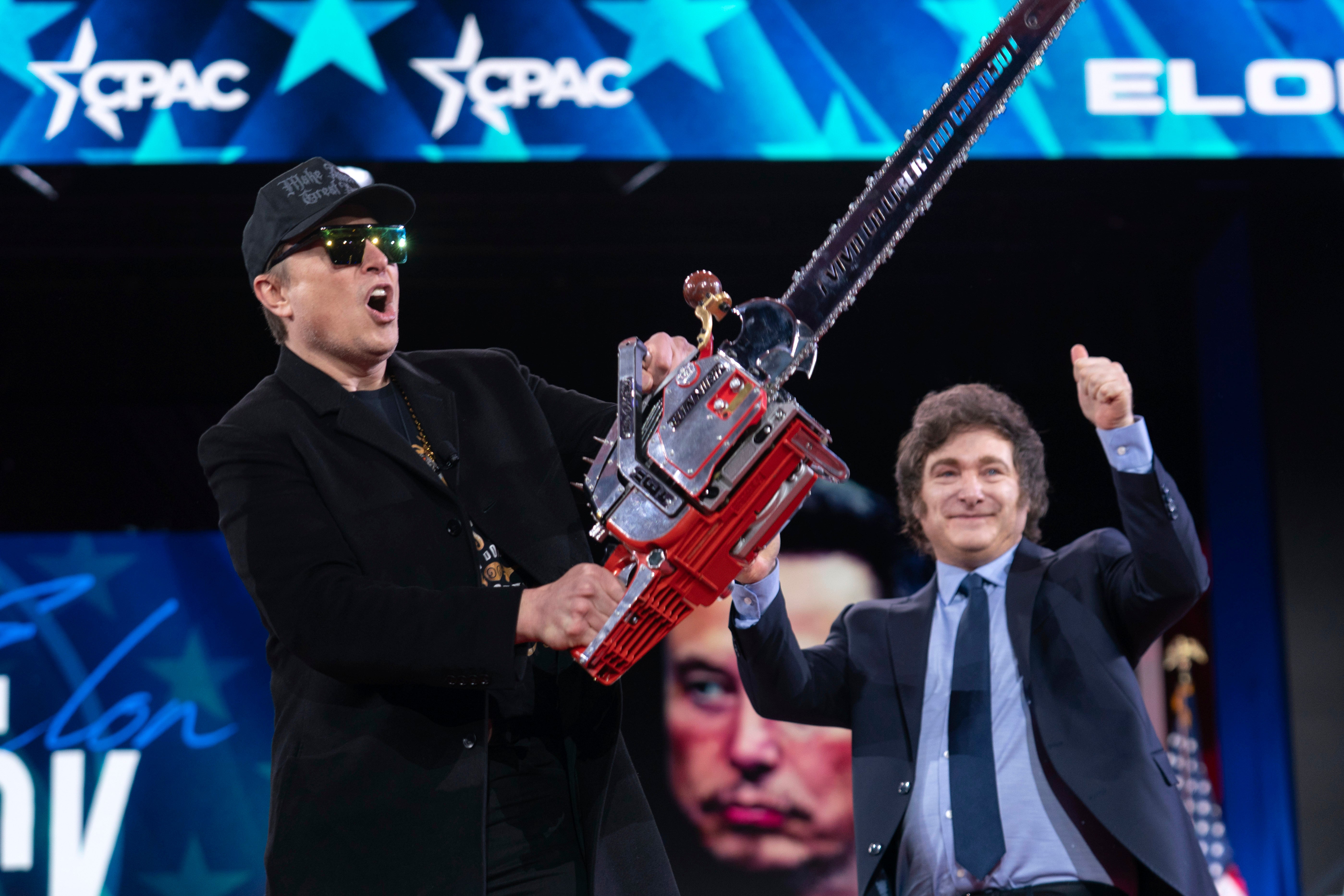 Elon Musk, left, receives a chainsaw from Argentinian President Javier Milei at the Conservative Political Action Conference in Maryland. Musk’s cuts to the federal government have cost tens of thousands of people their jobs, reportedly including 6,000 veterans