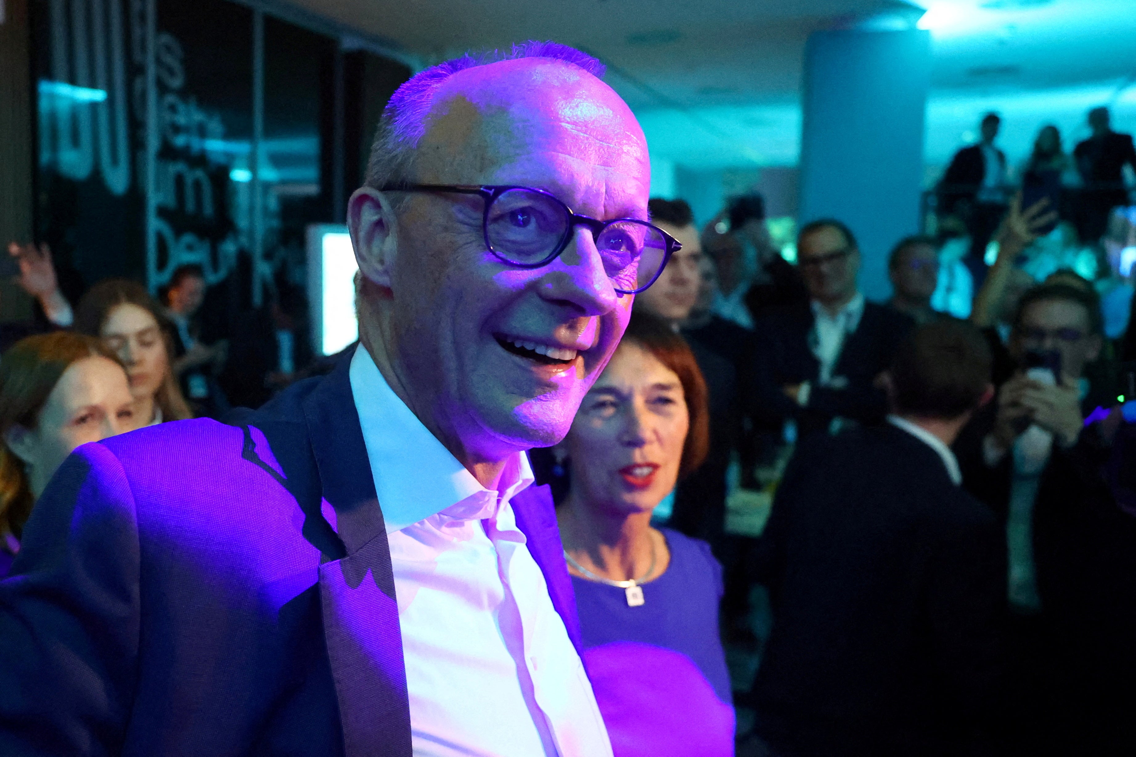 German conservative candidate for chancellor and Christian Democratic Union party leader Friedrich Merz and his wife Charlotte Merz react after the exit poll results are announced for the 2025 general election