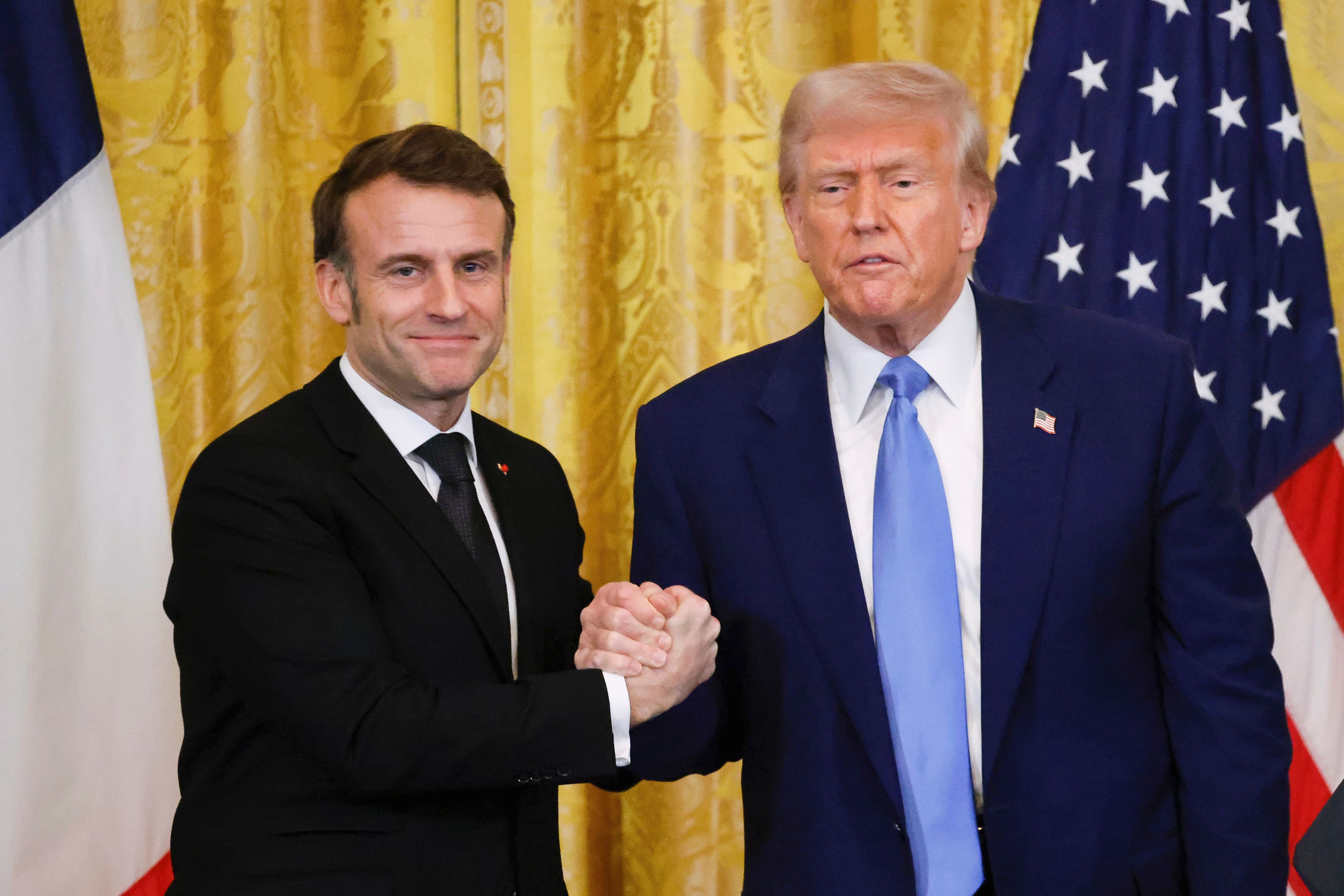 President Donald Trump, right, shakes the hand of France’s President Emmanuel Macron during a joint press conference in the East Room of the White House in Washington, Monday, Feb. 24, 2025. (Ludovic Marin/Pool via AP)