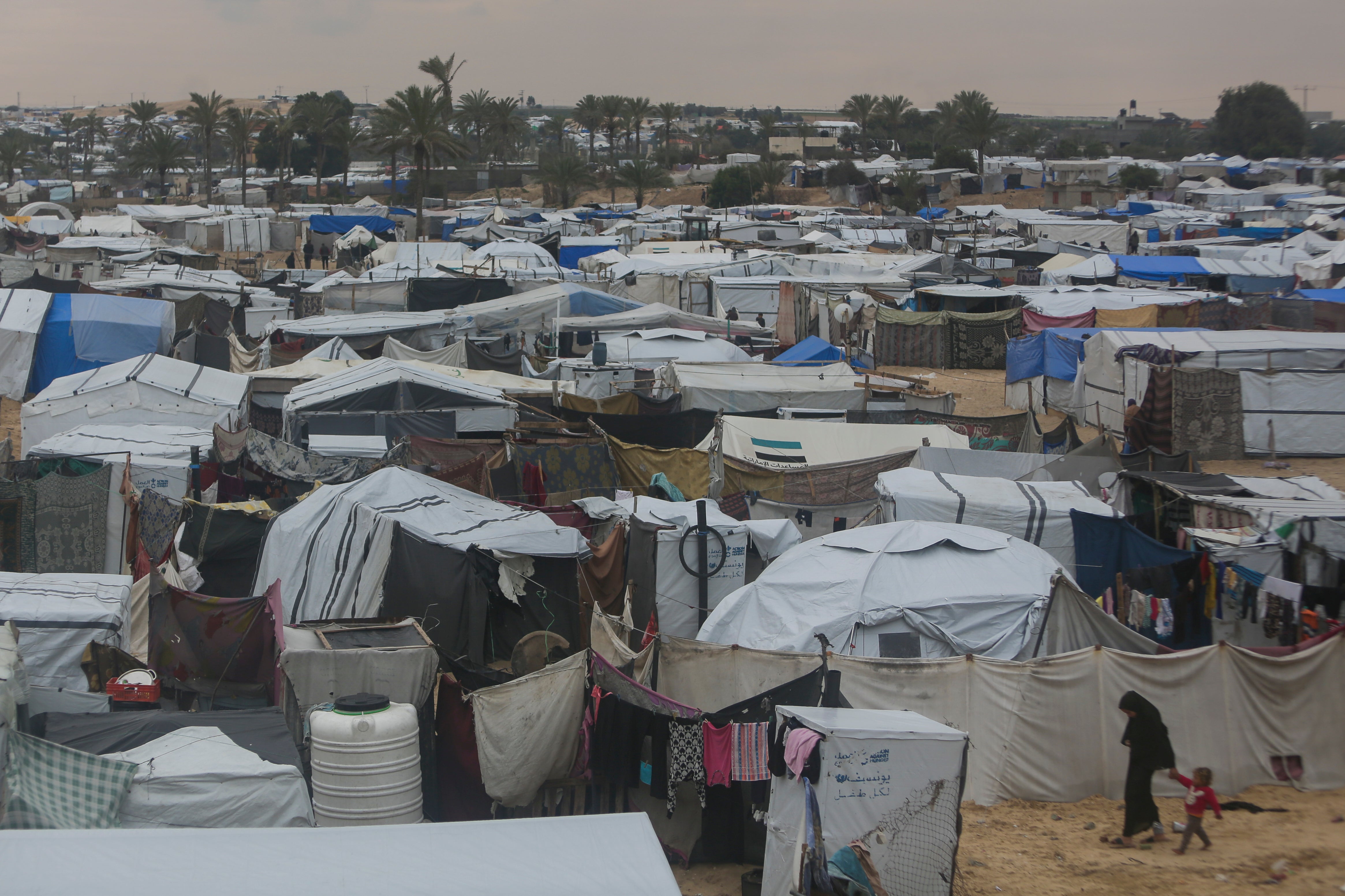 Palestinians displaced by the Israeli air and ground offensive on the Gaza Strip walk through a makeshift tent camp in Muwasi, Rafah, southern Gaza, Monday, February 24, 2025.