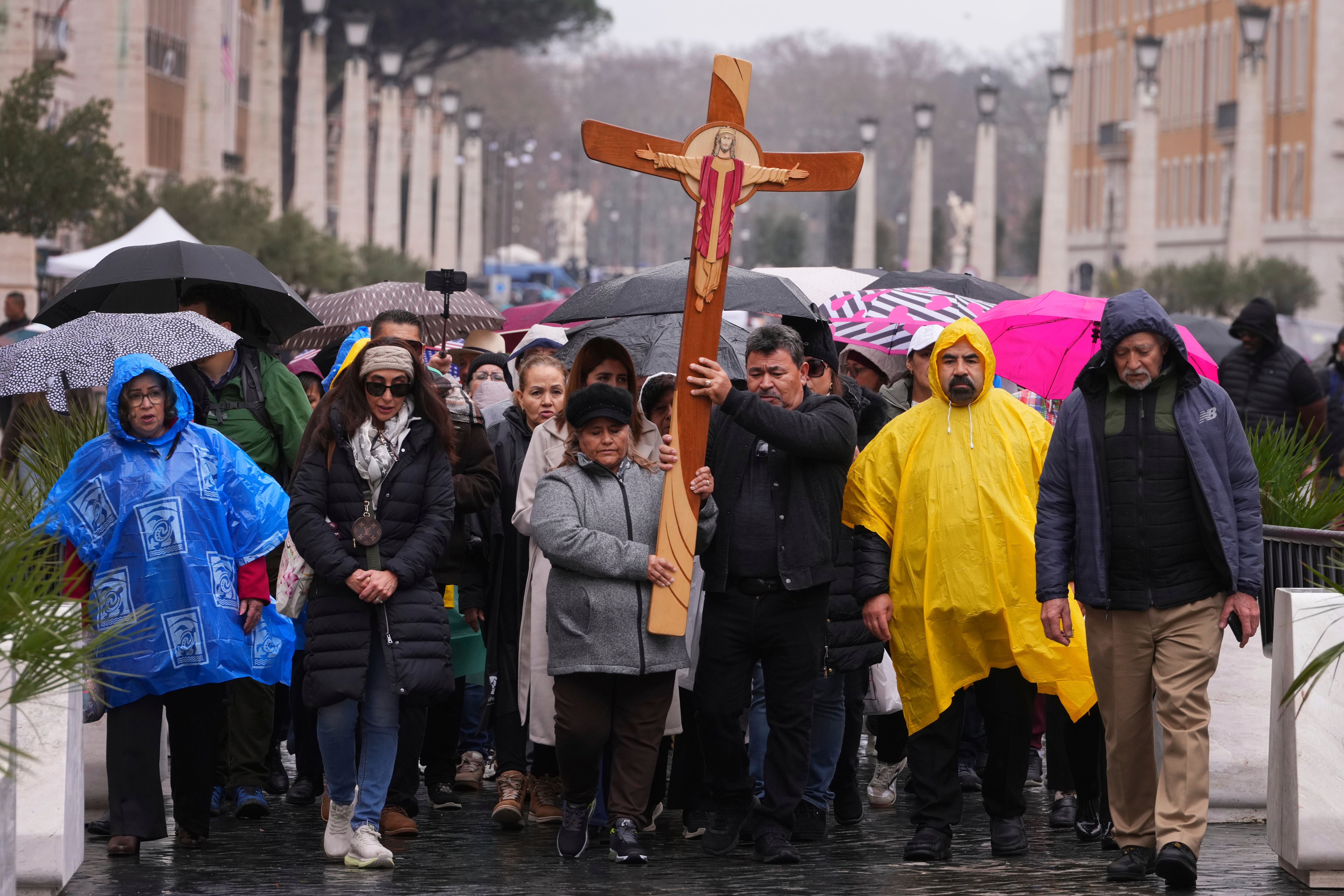 Pilgrims walk through the rain at the Vatican