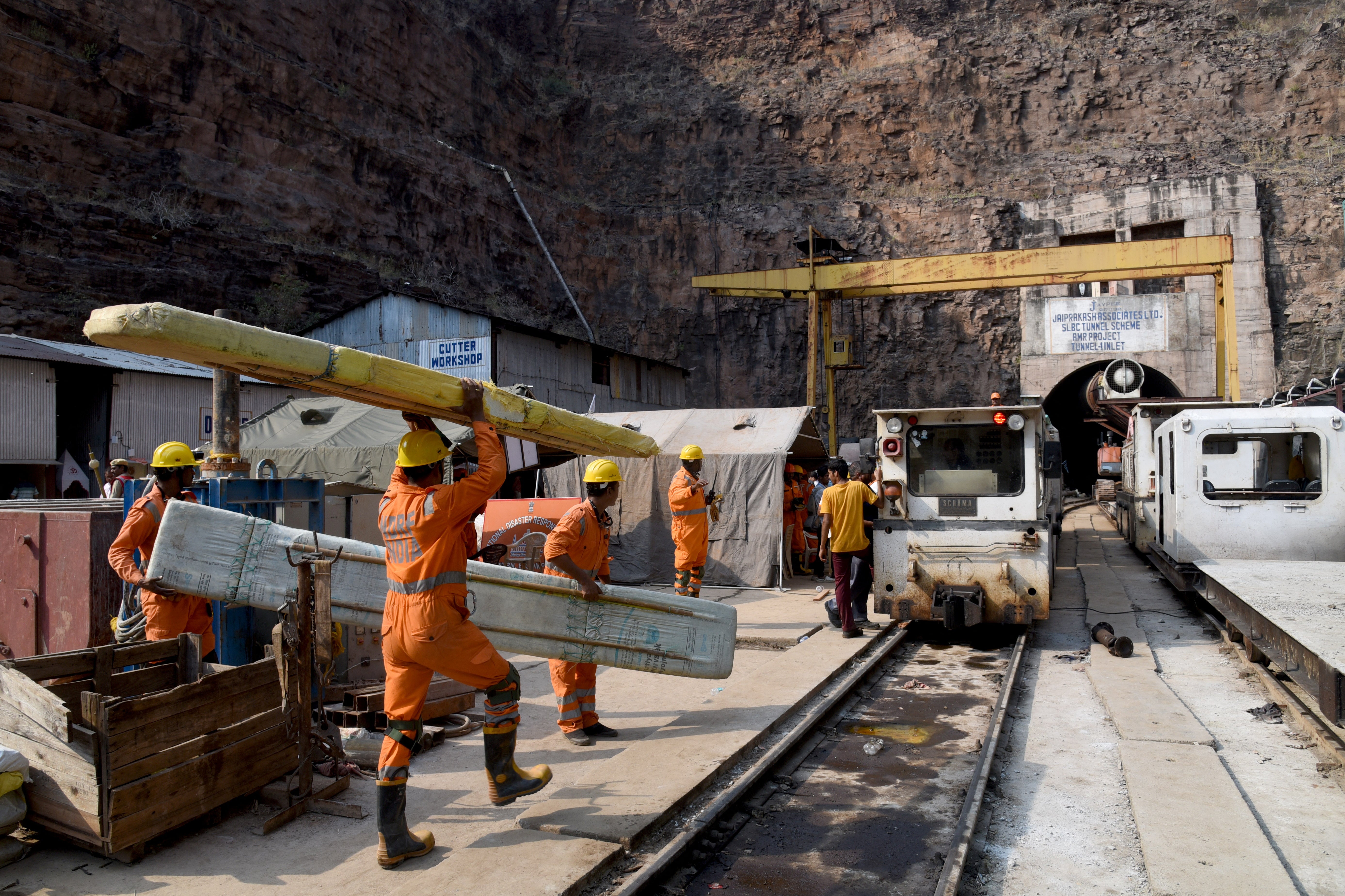 National Disaster Response Force personnel carry their equipment during a rescue operation outside the Srisailam Left Bank Canal tunnel in Telangana, India