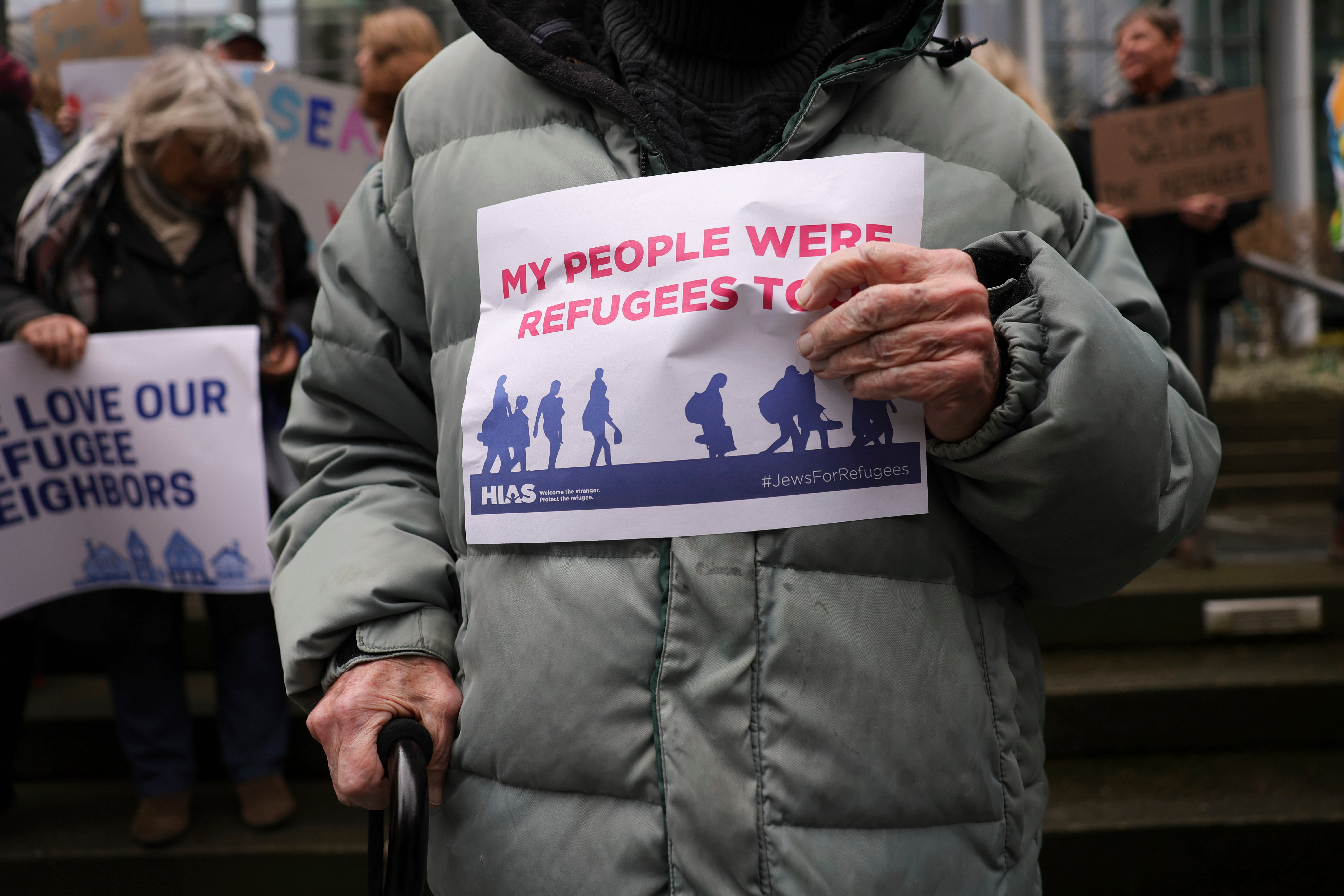 Martin Bernstein, 95, whose parents were refugees, holds a sign as people gather outside federal court in Seattle after a judge blocked Donald Trump's effort to halt the nation's refugee admissions system