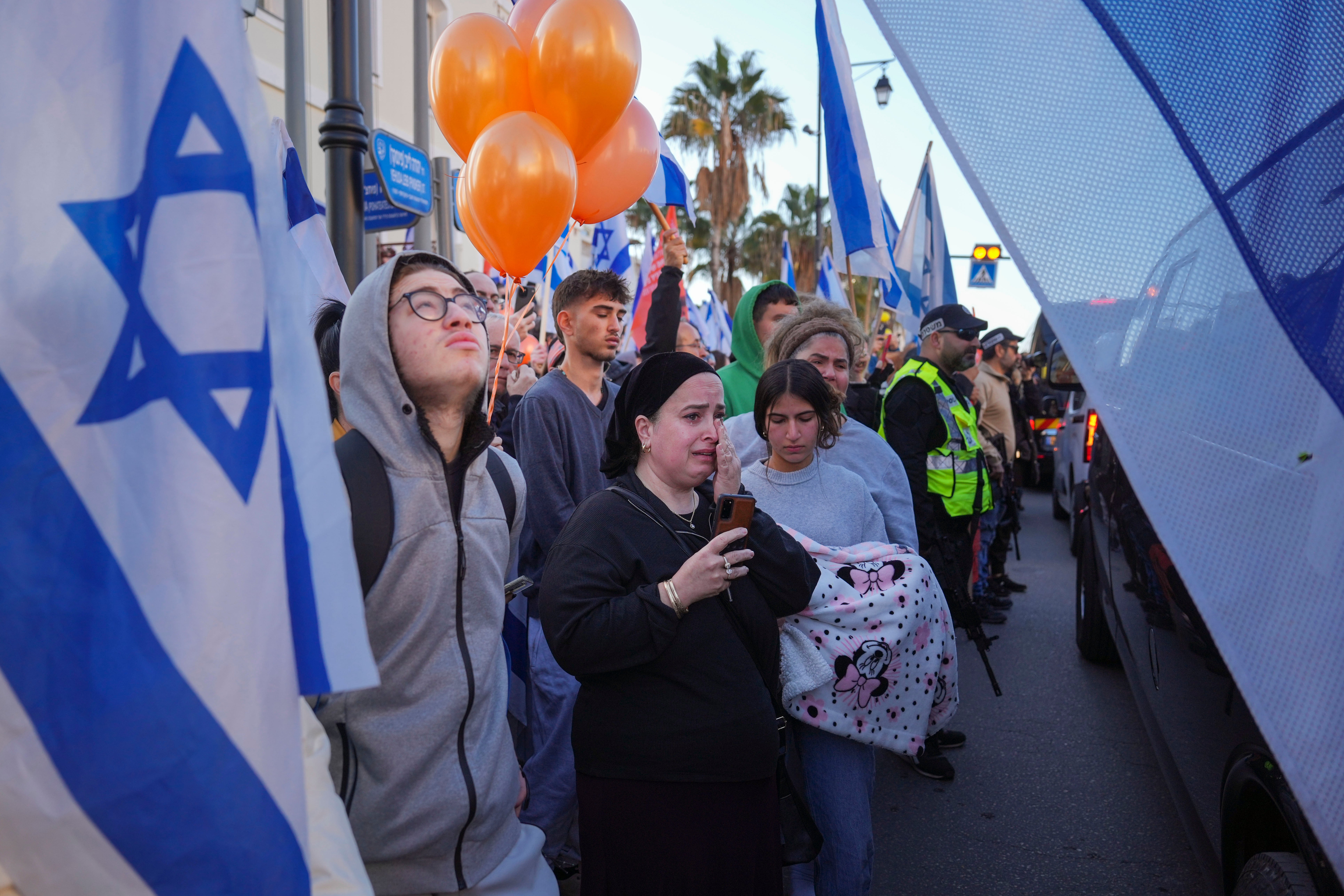 Mourners held flags and orange balloons