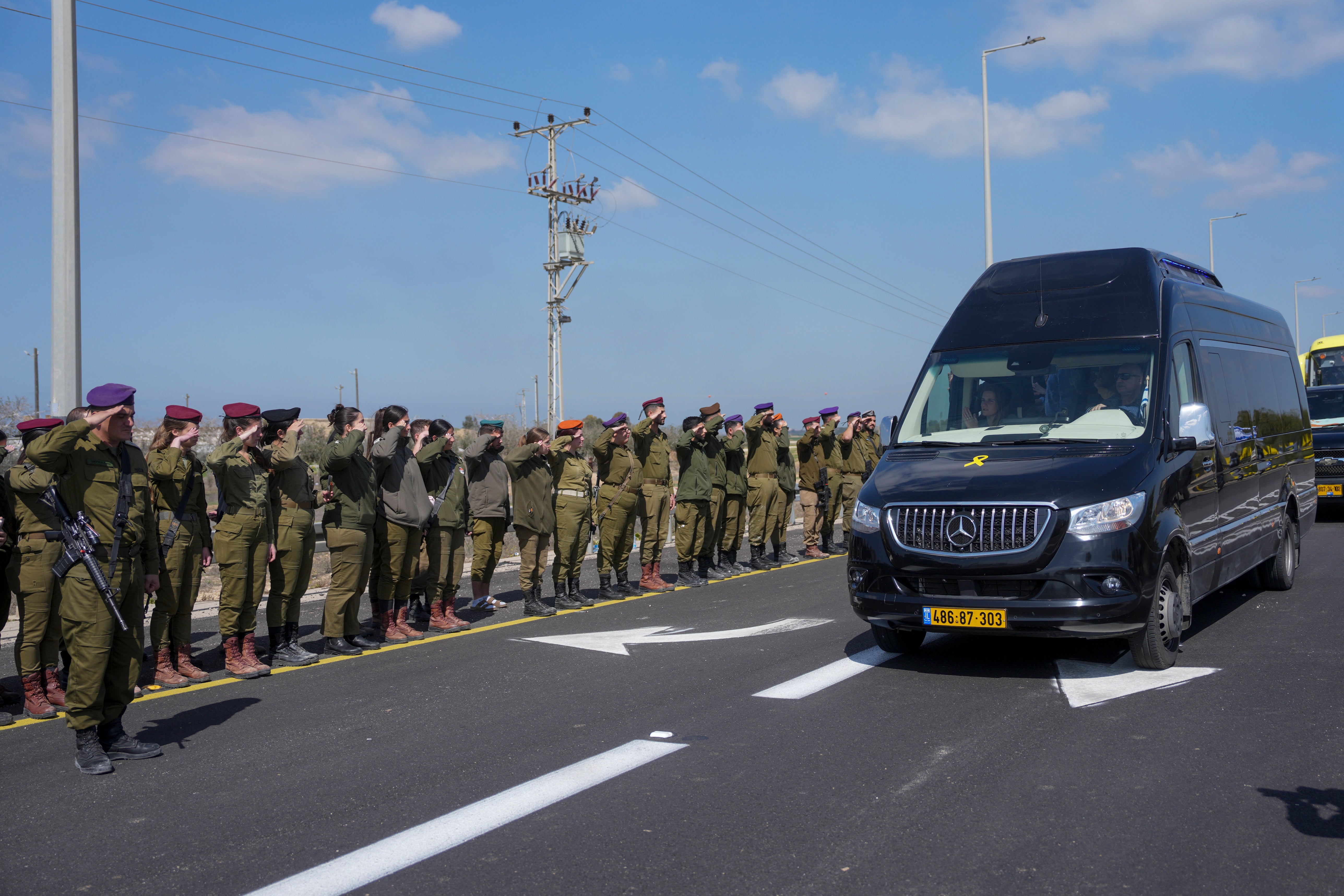 Israeli soldiers salute as the coffins pass