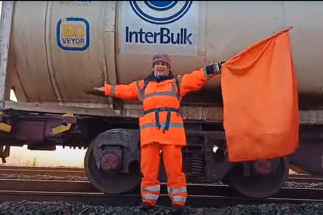BEST QUALITY AVAILABLE Undated handout video grab image issued by the Axe Drax protest group of retired GP Dr Diana Warner, 65, wearing orange hi-vis clothing and waving an orange flag having stopped a 400m long empty freight train near Drax power station, in East Yorkshire (Axe Drax/PA)