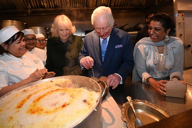 The King and Queen help pack donation boxes, with head chef Asha Pradhan and Darjeeling Express owner Asma Khan (Eddie Mulholland/Daily Telegraph/PA)