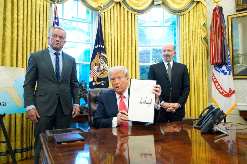 RFK Jr looks less than thrilled to see Trump hawking merchandise in the Oval Office