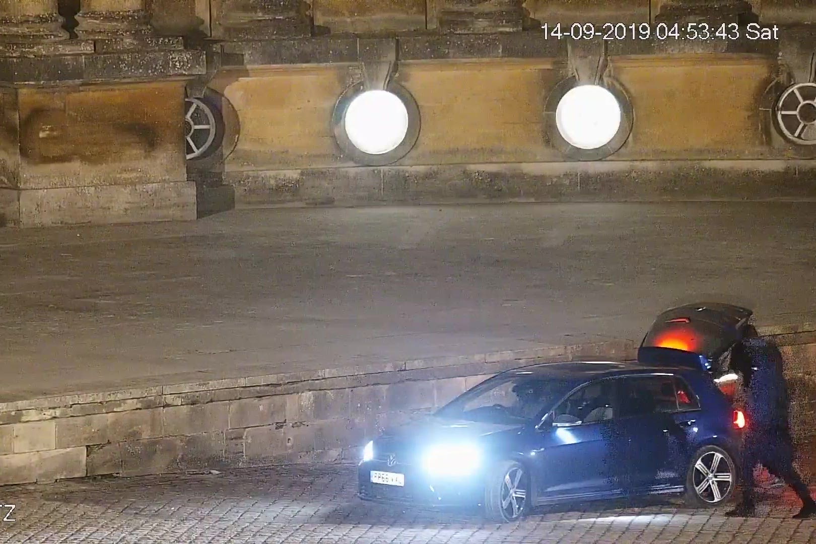A CCTV image showing three men loading a large object into the boot of the vehicle in the courtyard at Blenheim Palace (Thames Valley Police/PA)